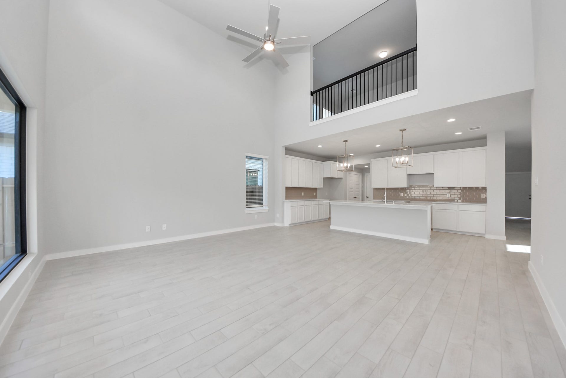15111 Statice Trail, Houston, TX 77044 Family room flooded with natural light through the expansive windows. The premium tile flooring adds a touch of luxury to the space, creating the perfect setting for relaxing moments and cherished gatherings with loved ones
