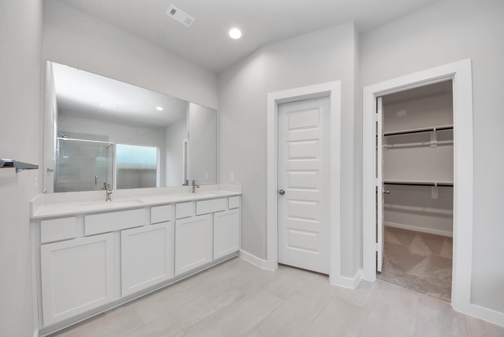 15111 Statice Trail, Houston, TX 77044 Elevate your daily routine at the elegant vanity, now equipped with double sinks, light countertops, modern hardware, and beautiful recessed lights.