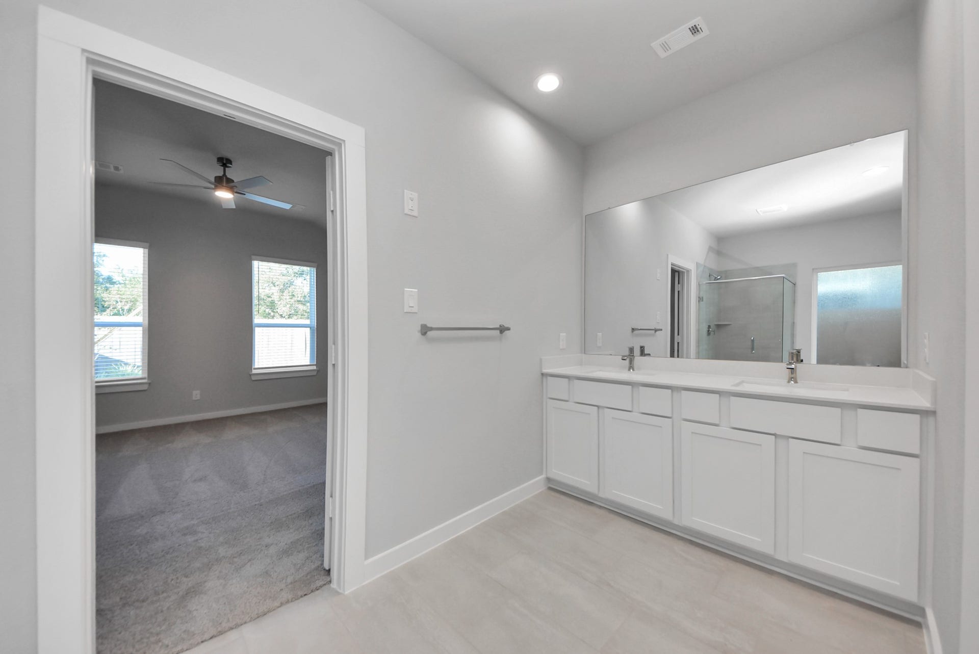 15111 Statice Trail, Houston, TX 77044 Escape to a spa-like oasis in this primary bathroom. Enjoy a walk-in shower with tile surround, a separate garden tub with custom detailing, and an elegant vanity featuring light countertops, modern hardware, and beautiful vanity lights. Experience luxury and relaxation in every detail.