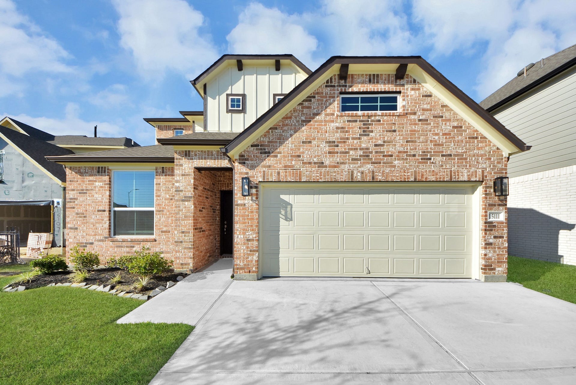 15111 Statice Trail, Houston, TX 77044 Meticulously maintained yard and lush landscape, paired with a premium elevation featuring captivating brick accents. Modern coach lights add a touch of contemporary elegance to the exterior.