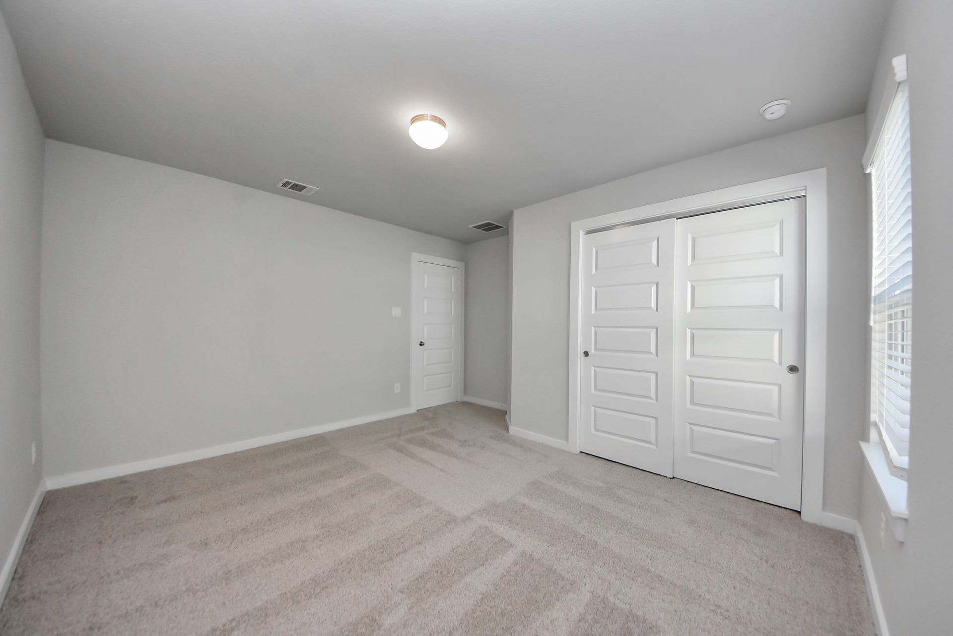 15111 Statice Trail, Houston, TX 77044 Secondary bedroom features plush carpeting, large windows that let in plenty of natural light, bright paint, and spacious closets.