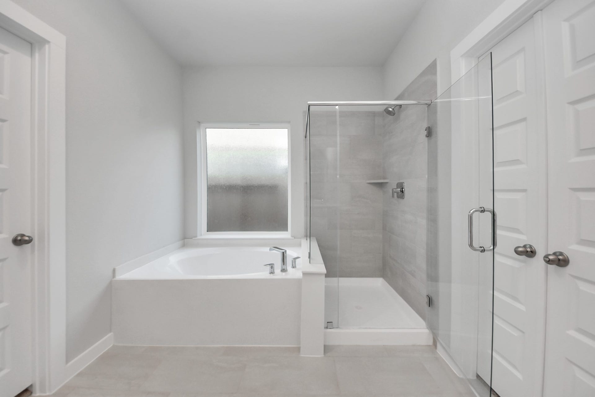 15111 Statice Trail, Houston, TX 77044 Indulge in a spa-like retreat within the confines of this primary bathroom. Delight in a spacious walk-in shower enveloped in stylish tile surround, unwind in a separate garden tub adorned with custom detailing.