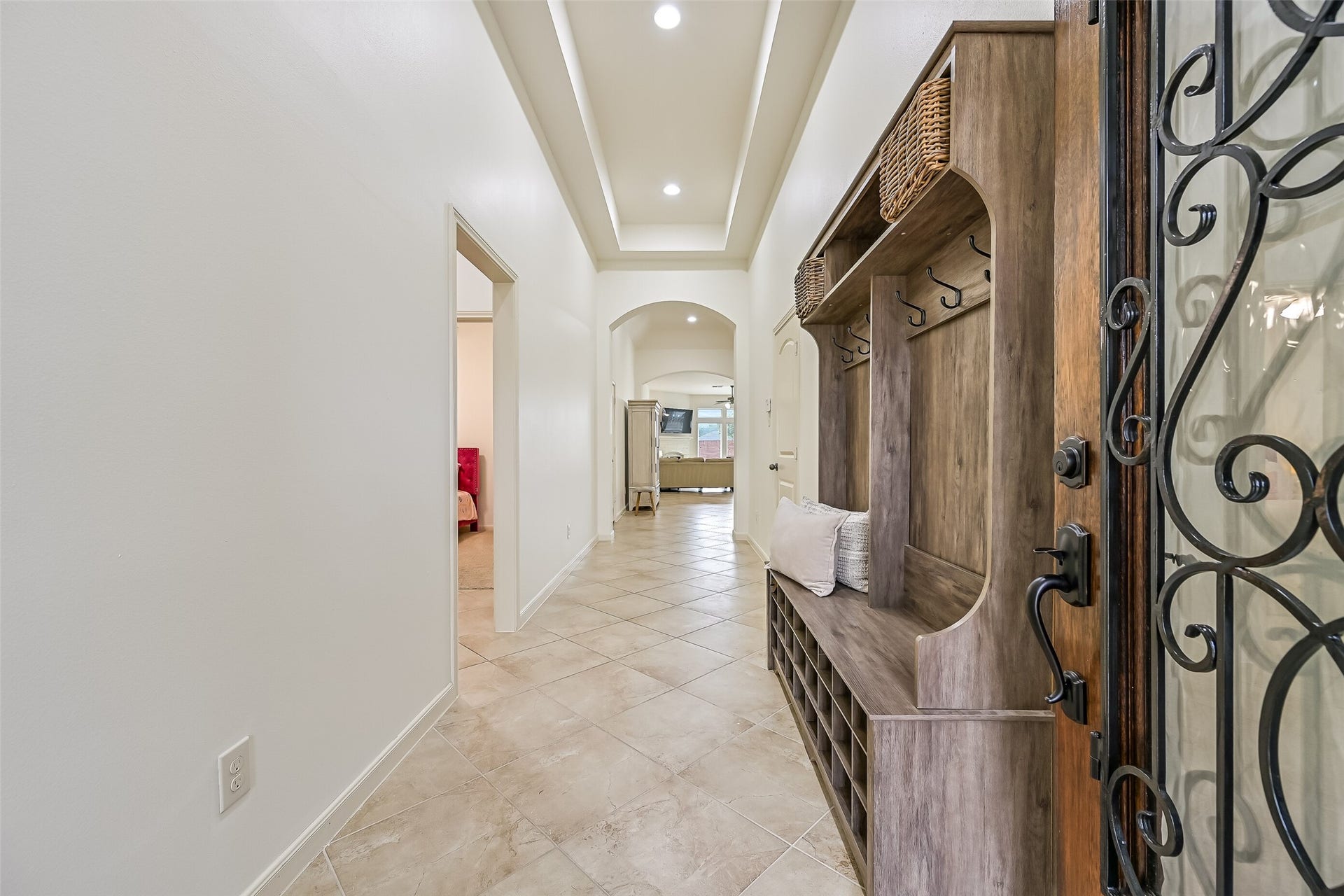 Step inside to a welcoming entry featuring a recessed tray ceiling with lighting, diagonally laid tile flooring & freshly painted neutral walls. Graceful arched openings draw your eye toward the spacious family room at the rear of the home, creating an inviting introduction to this single-story floor plan.