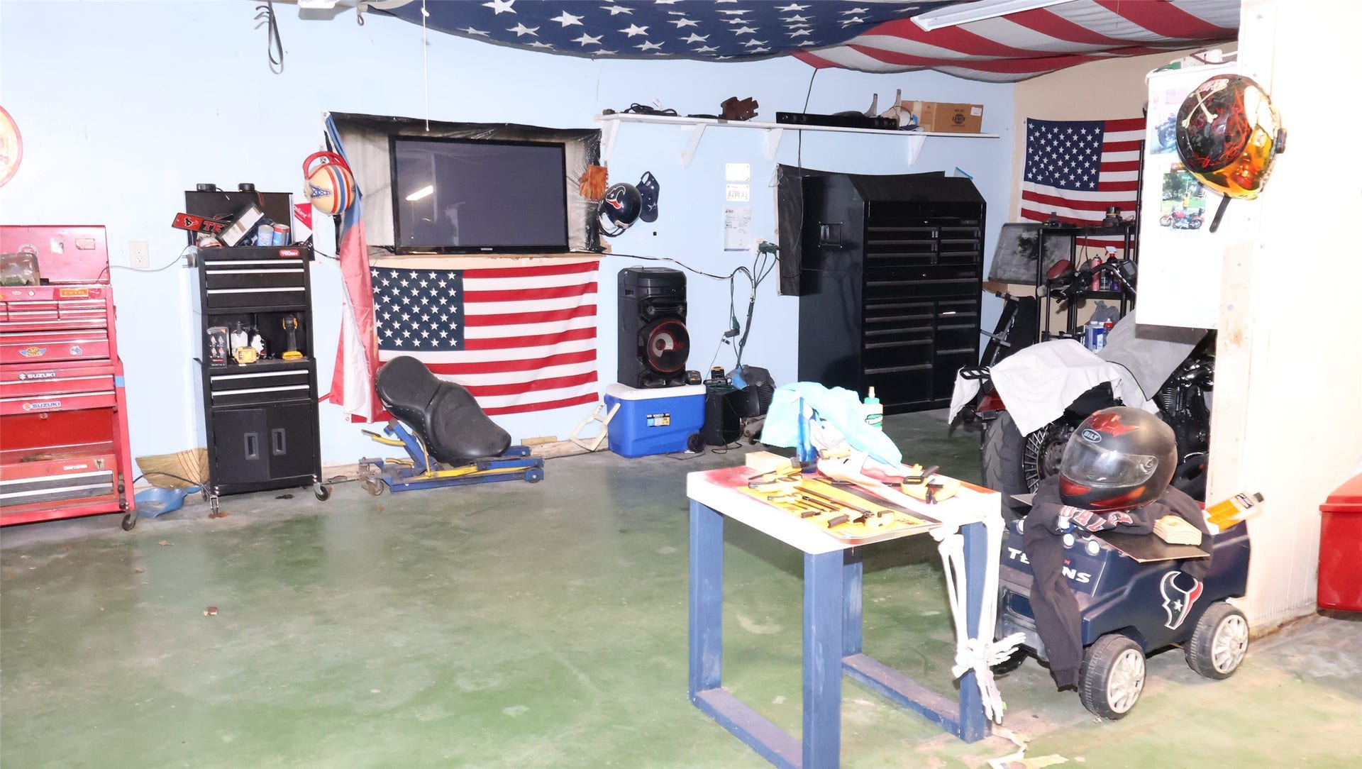 7029 Church Lane, Hitchcock, TX 77563 Spacious one-car garage with ample storage, tool chests, and a workbench, perfect for DIY enthusiasts.