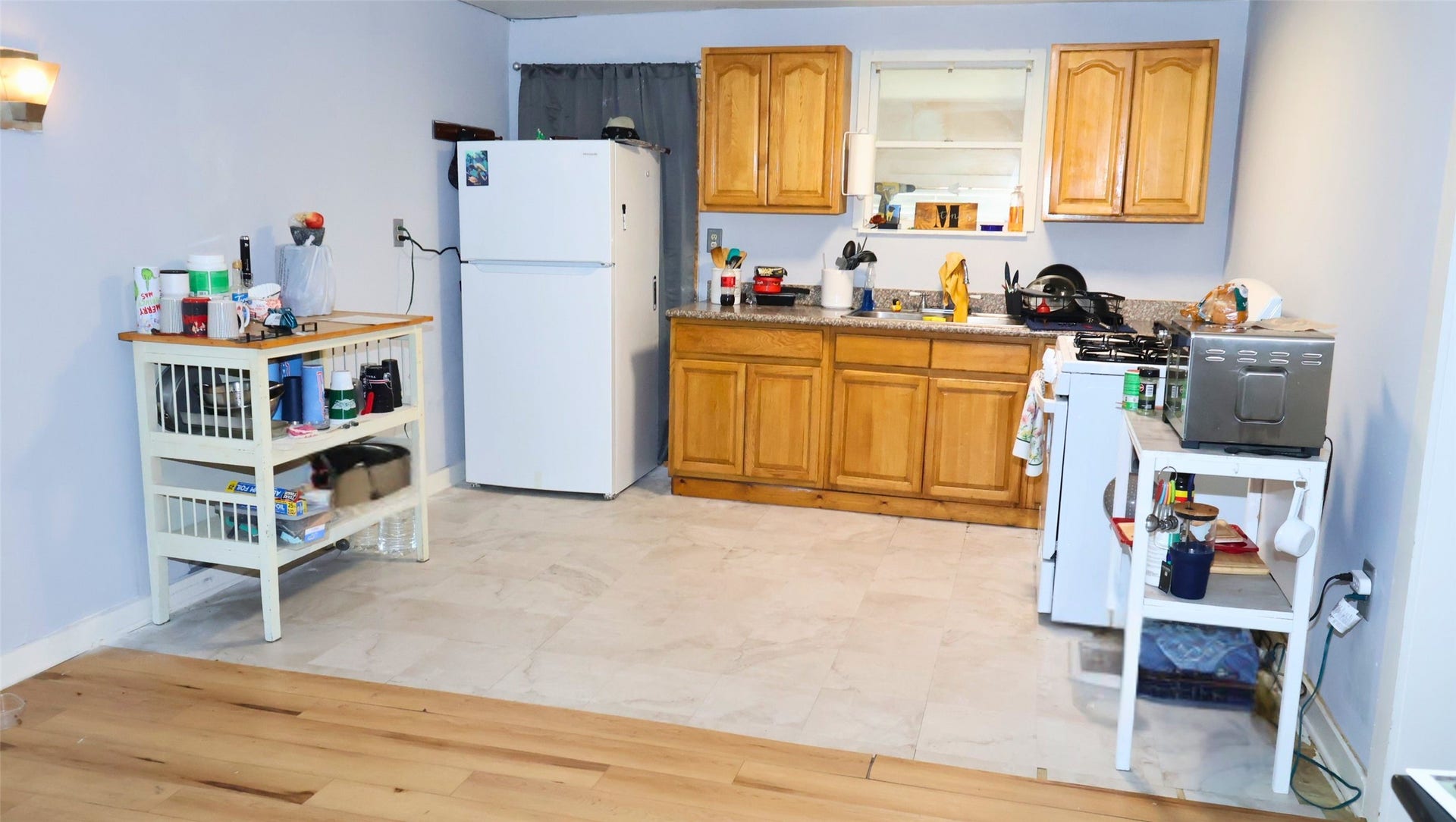 7029 Church Lane, Hitchcock, TX 77563 Cozy kitchen with wooden cabinets, ample counter space, and a practical layout featuring a fridge, stove, and microwave.