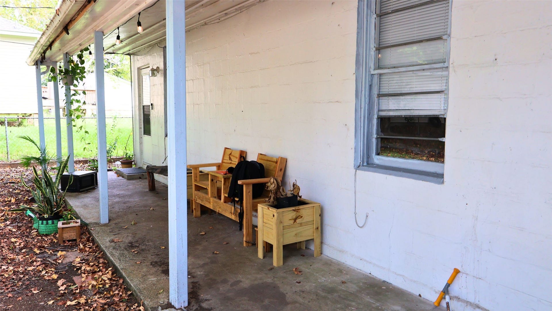 7029 Church Lane, Hitchcock, TX 77563 Charming covered patio with cozy seating, perfect for relaxing and enjoying the outdoors.