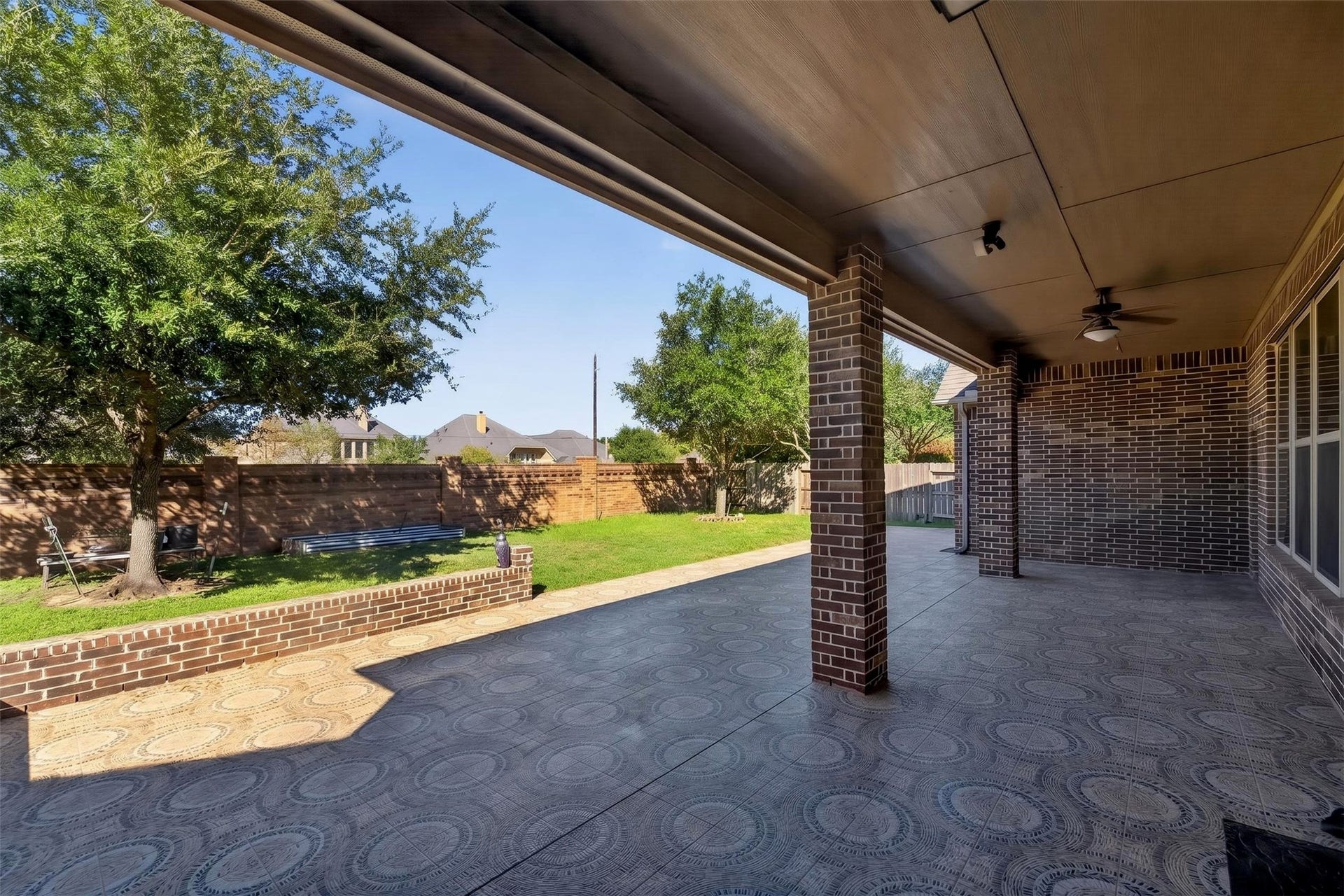 27818 Burchfield Grove Lane, Katy, TX 77494 Extend your living space outdoors beneath the expansive covered patio, complete with a ceiling fan and ample room for seating or dining. The patterned patio flooring adds visual interest, creating an inviting setting for weekend gatherings or quiet evenings outside.