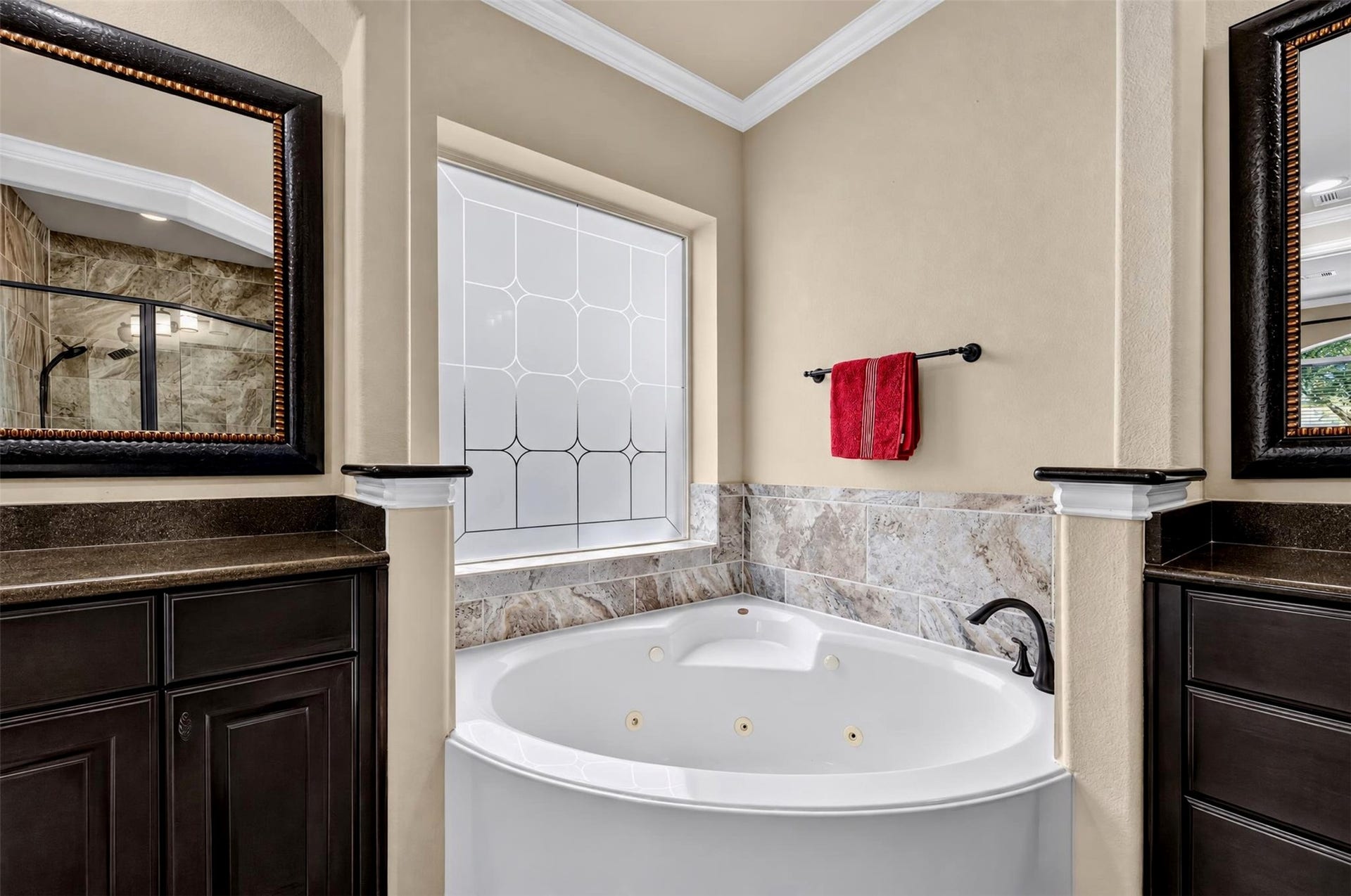 27818 Burchfield Grove Lane, Katy, TX 77494 Enjoy a relaxing escape in the jetted soaking tub, framed by decorative tile accents and a distinctive geometric privacy window. The surrounding ledges and nearby cabinetry provide convenient places for bath essentials.