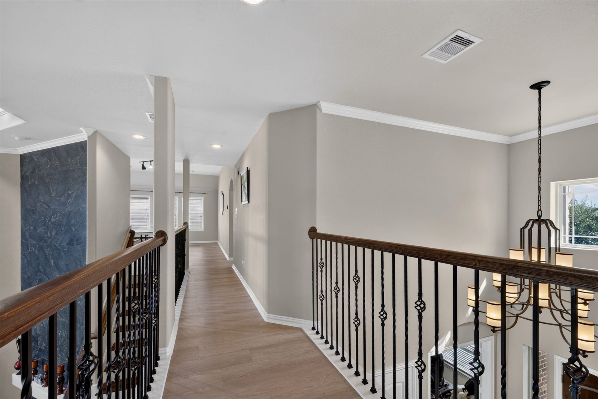 27818 Burchfield Grove Lane, Katy, TX 77494 Wood-look flooring and decorative iron railing continue the home's architectural details along the hallway.