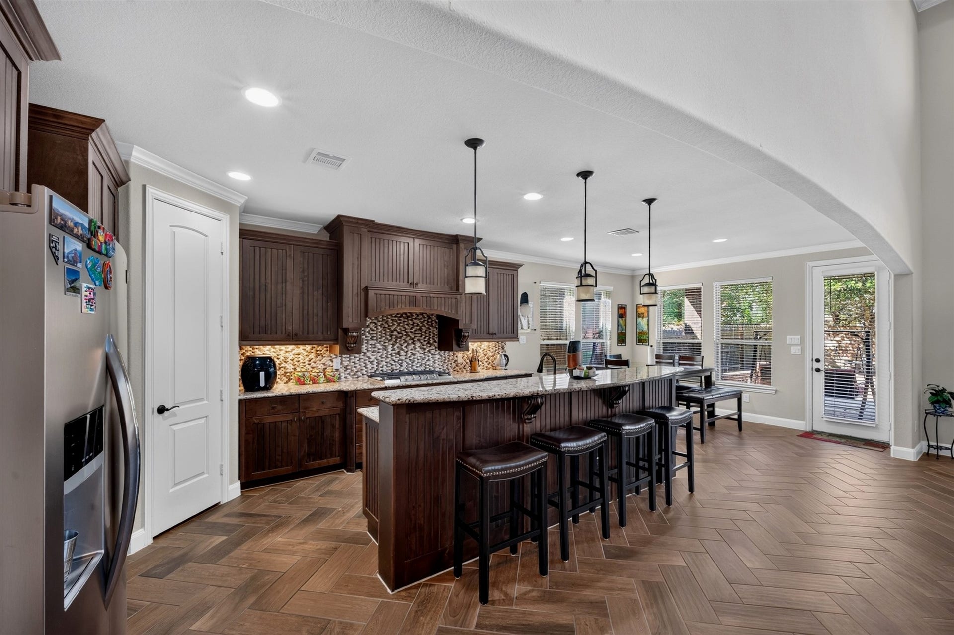 27818 Burchfield Grove Lane, Katy, TX 77494 The kitchen opens into a bright dining area, creating a natural gathering place for busy mornings and casual meals. Rich maple cabinetry, granite countertops, pendant lighting, and abundant windows give this space both warmth and functionality.