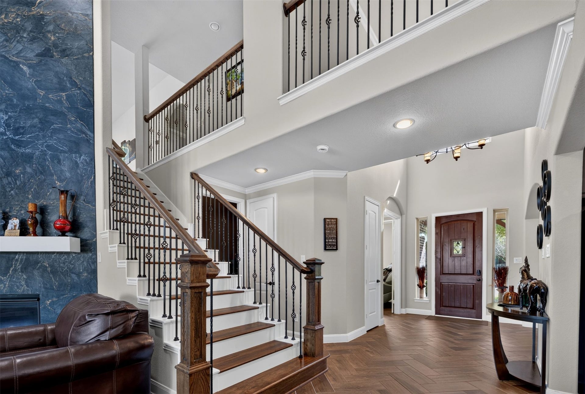 27818 Burchfield Grove Lane, Katy, TX 77494 Returning to the main living area, the staircase makes a striking impression with dark wood treads, substantial wood handrails, and decorative wrought-iron balusters.