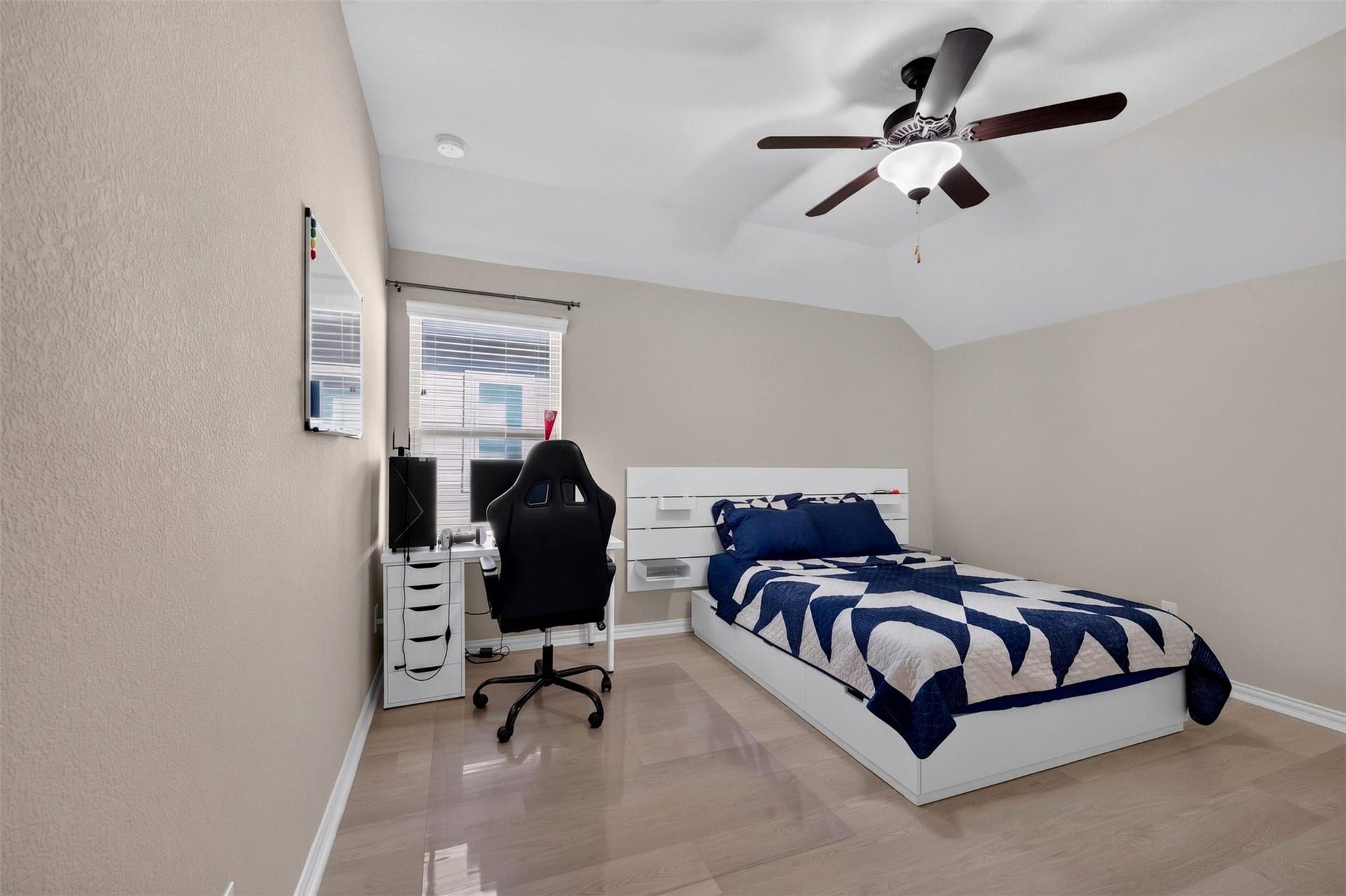 27818 Burchfield Grove Lane, Katy, TX 77494 This upstairs bedroom features a vaulted ceiling that enhances the sense of openness, along with light wood-look flooring and a ceiling fan. Neutral finishes offer a flexible backdrop for a variety of furniture arrangements and personal styles. Opposite the bed is a double-door closet that provides convenient storage.