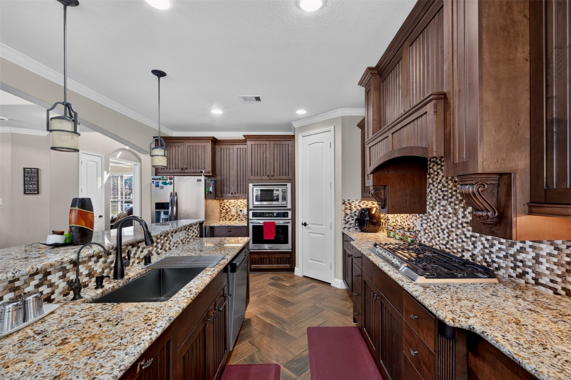 27818 Burchfield Grove Lane, Katy, TX 77494 A closer look reveals the kitchen's thoughtful details, including granite countertops, a decorative mosaic backsplash, rich cabinetry, and a stainless-steel sink. The generous work surfaces provide plenty of room to prepare meals while keeping everything within reach.