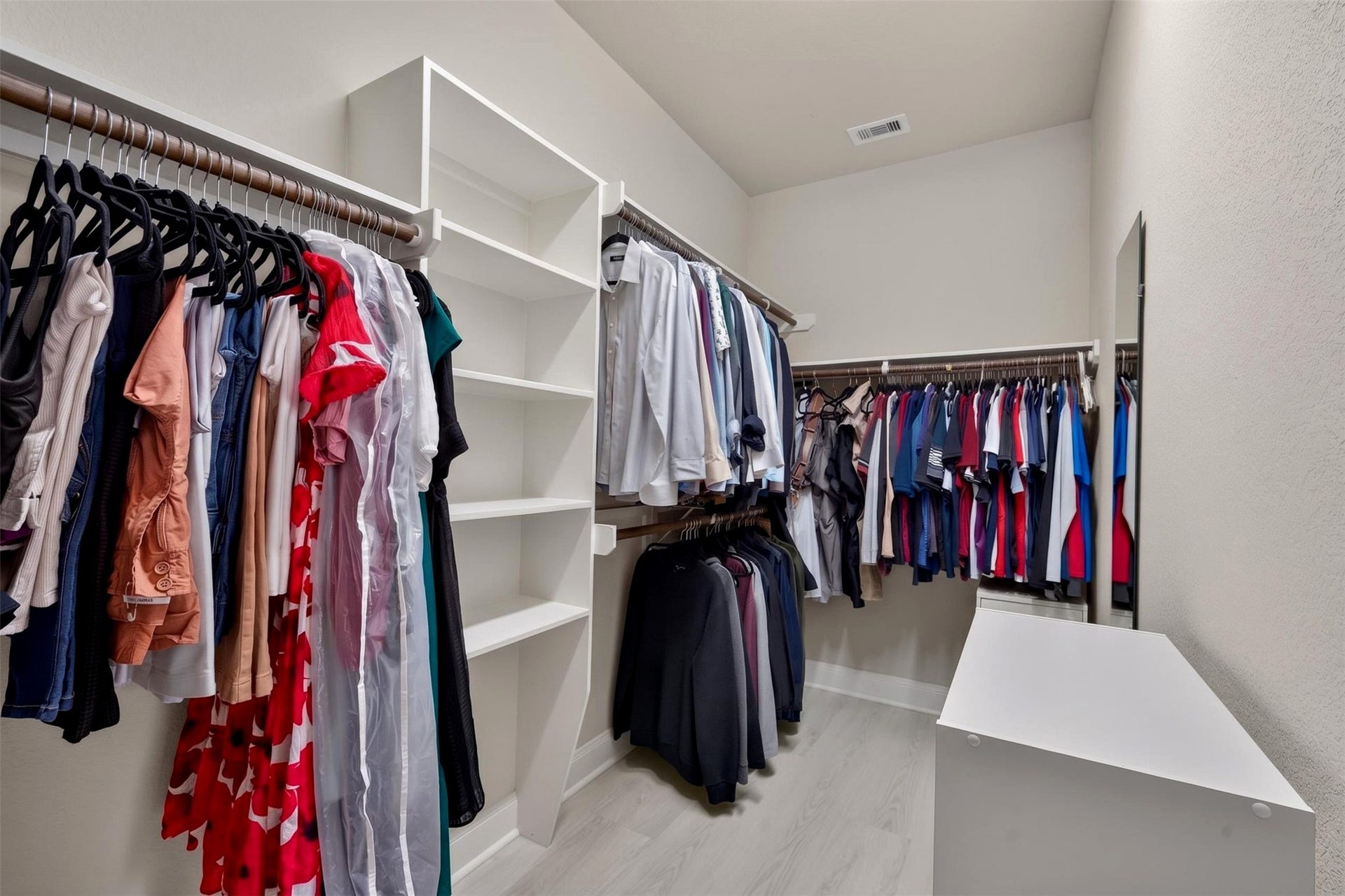 27818 Burchfield Grove Lane, Katy, TX 77494 The walk-in closet offers extensive hanging space along multiple walls, complemented by open shelving for folded clothing and accessories. A central storage island adds another convenient spot to organize everyday essentials.
