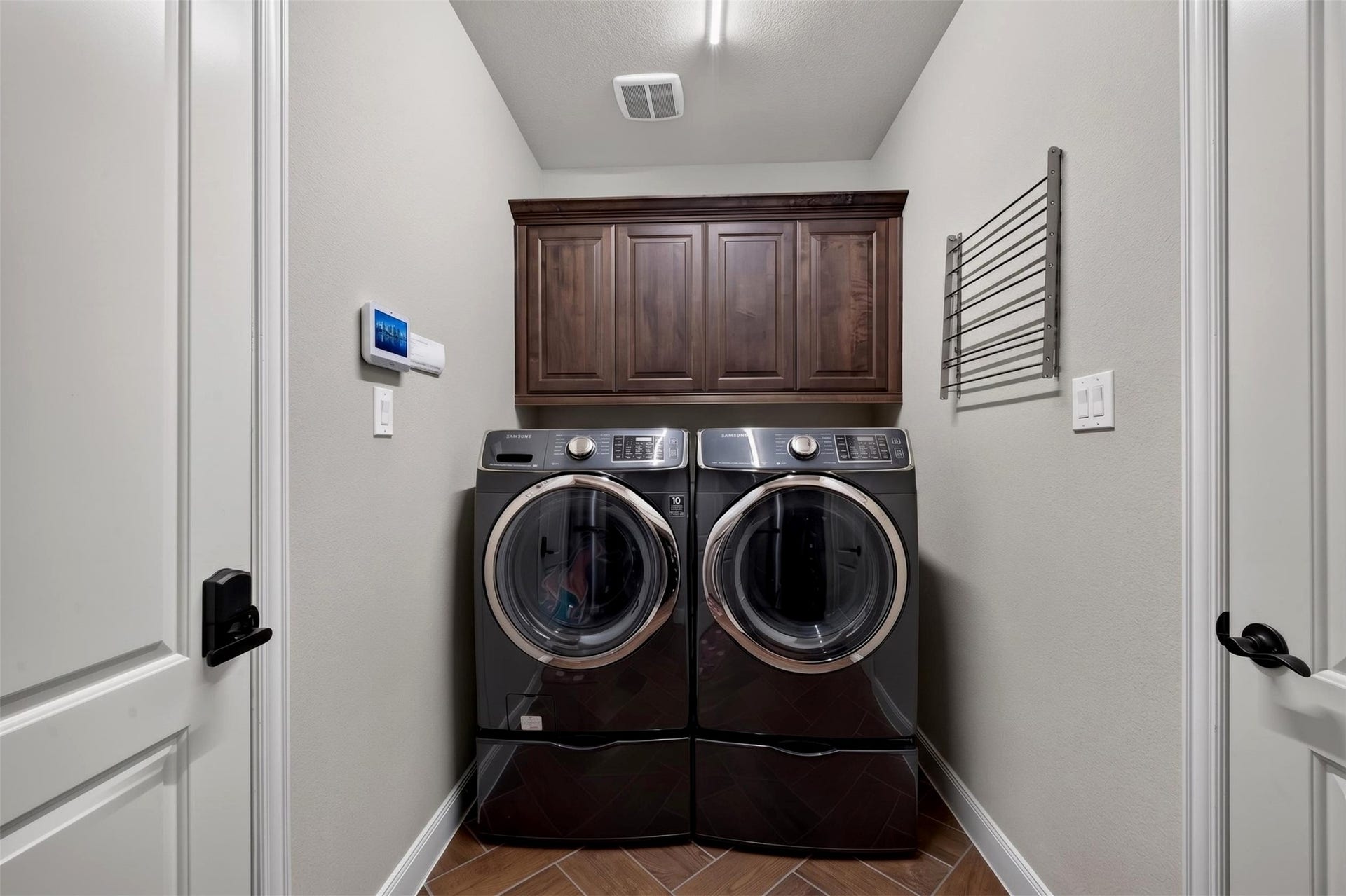27818 Burchfield Grove Lane, Katy, TX 77494 Even everyday chores feel more organized in this dedicated utility room. Front-loading washer and dryer units sit beneath built-in cabinetry, providing convenient storage and a neat, functional laundry space.
