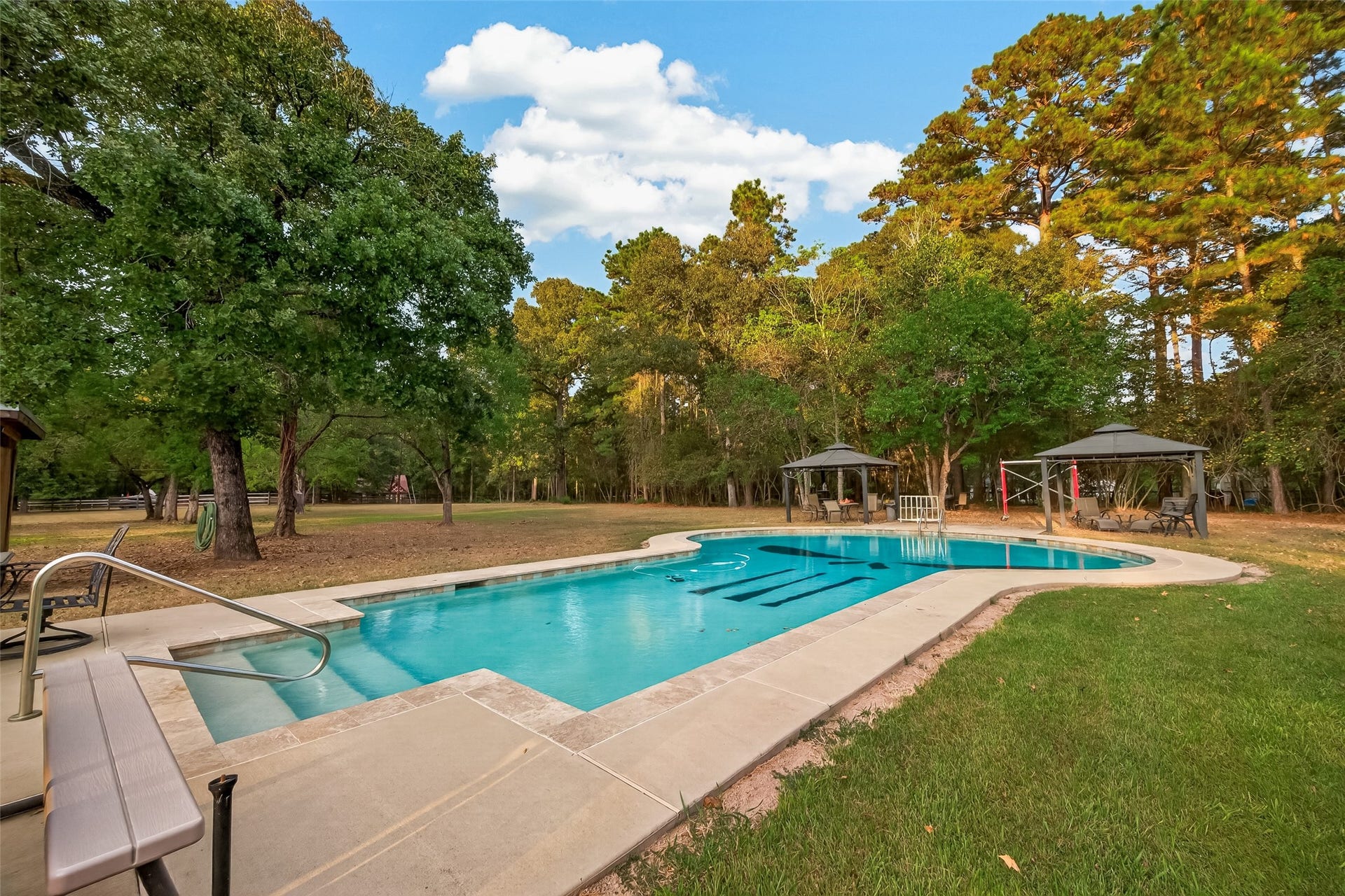 18614 Mink Lake Drive, Magnolia, TX 77355 Inviting swimming pool surrounded by mature trees and open outdoor space.