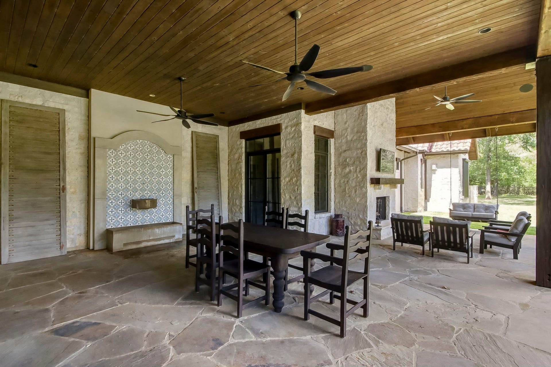 Part of the expansive covered patio area with flagstone decking, a water feature and outdoor wood burning fireplace. Souna system throughout the home and patio areas.