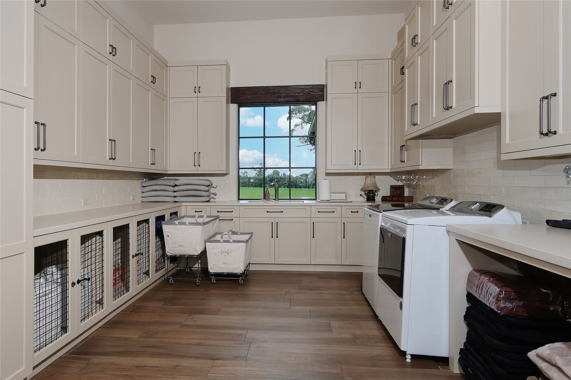 Enter through pocket doors from the caterers kitchen to the laundry room. A large sink for hand washing, plenty of countertop space for folding and loads of cabinet and drawer storage.