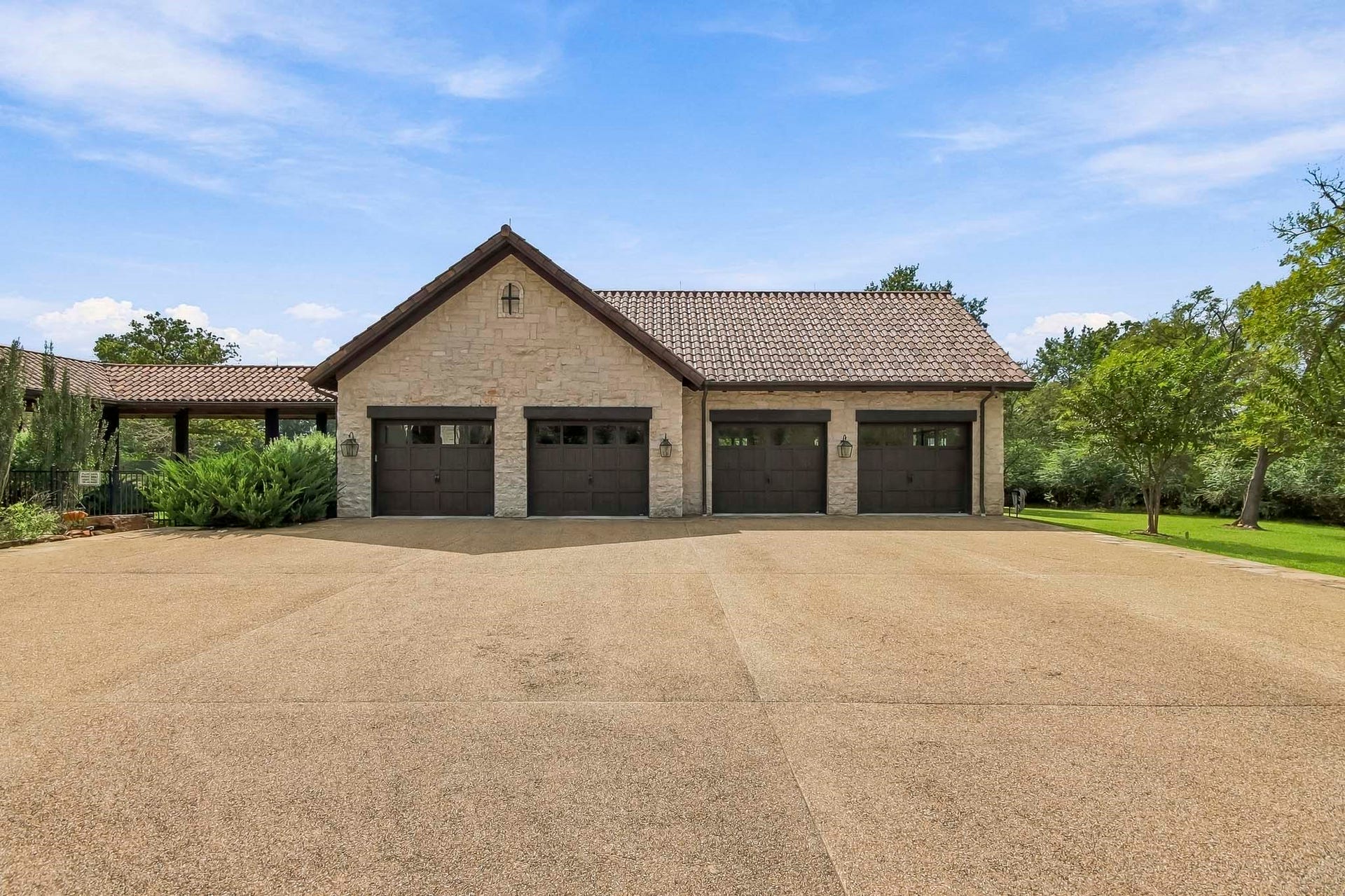 The oversized four car garage and ample additional parking for guests. Epoxy flooring and remote controlled stairs provides access to a decked attic space. A dog shower for muddy paws is another unique feature.