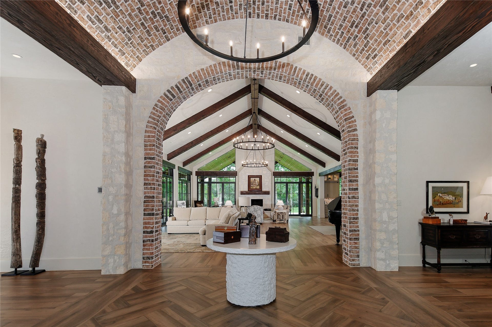 The grand entry with stone walls, solid wood beams, barrel ceiling and herringbone detail flooring sets the tone for this incredible home.