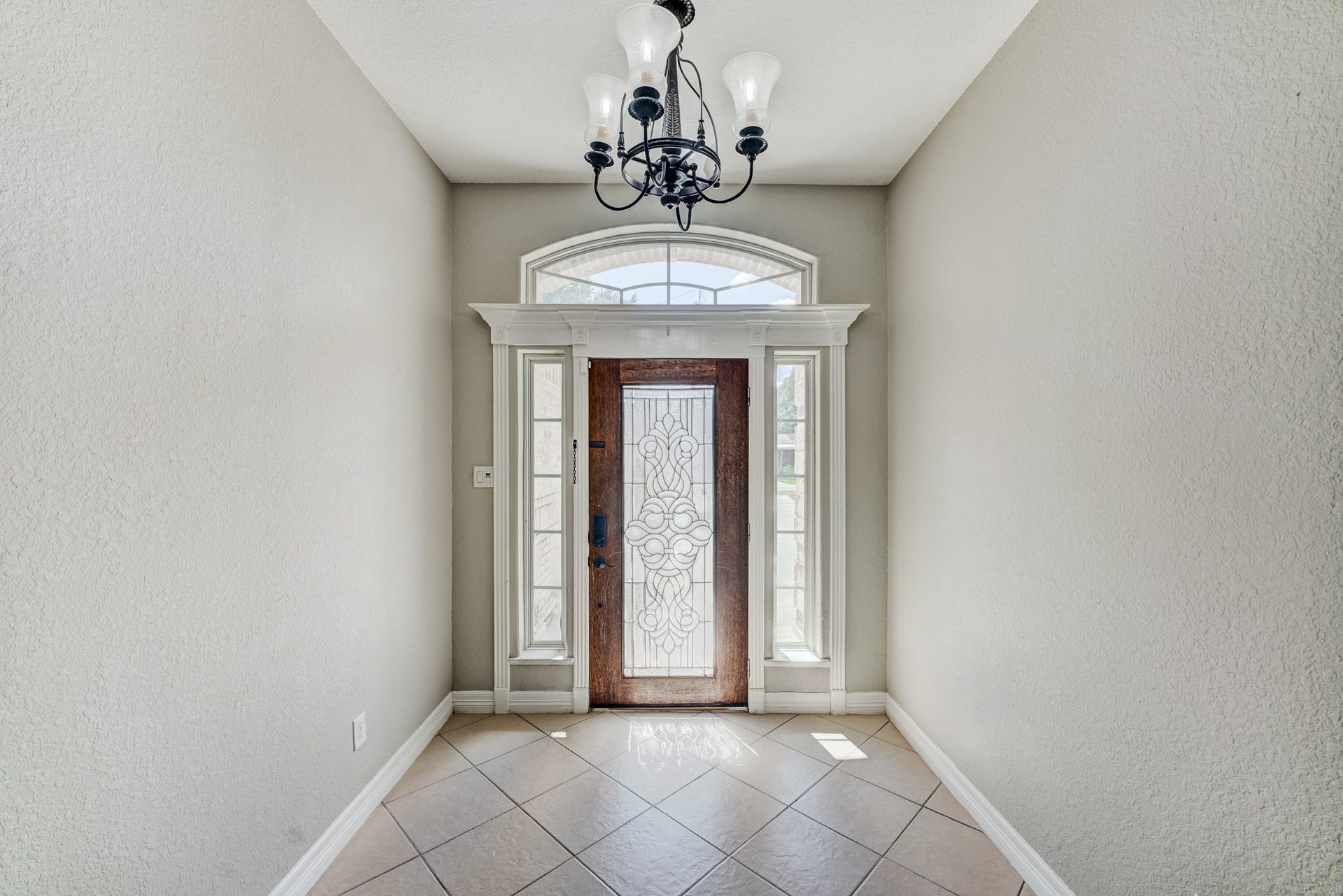 Elegant entry hall accented by decorative lighting and natural light.