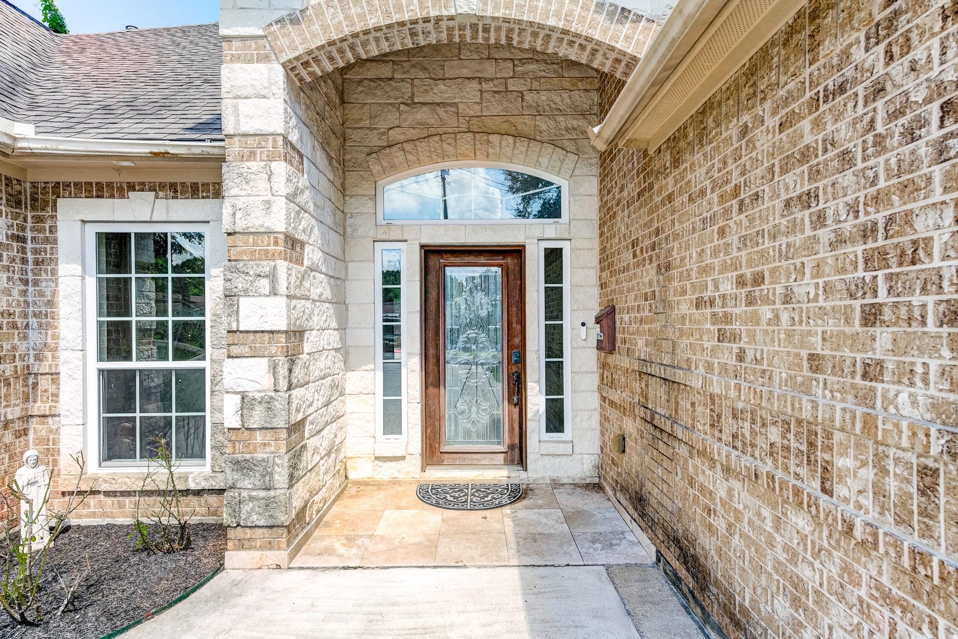 Grand covered porch leading to a decorative glass front door.