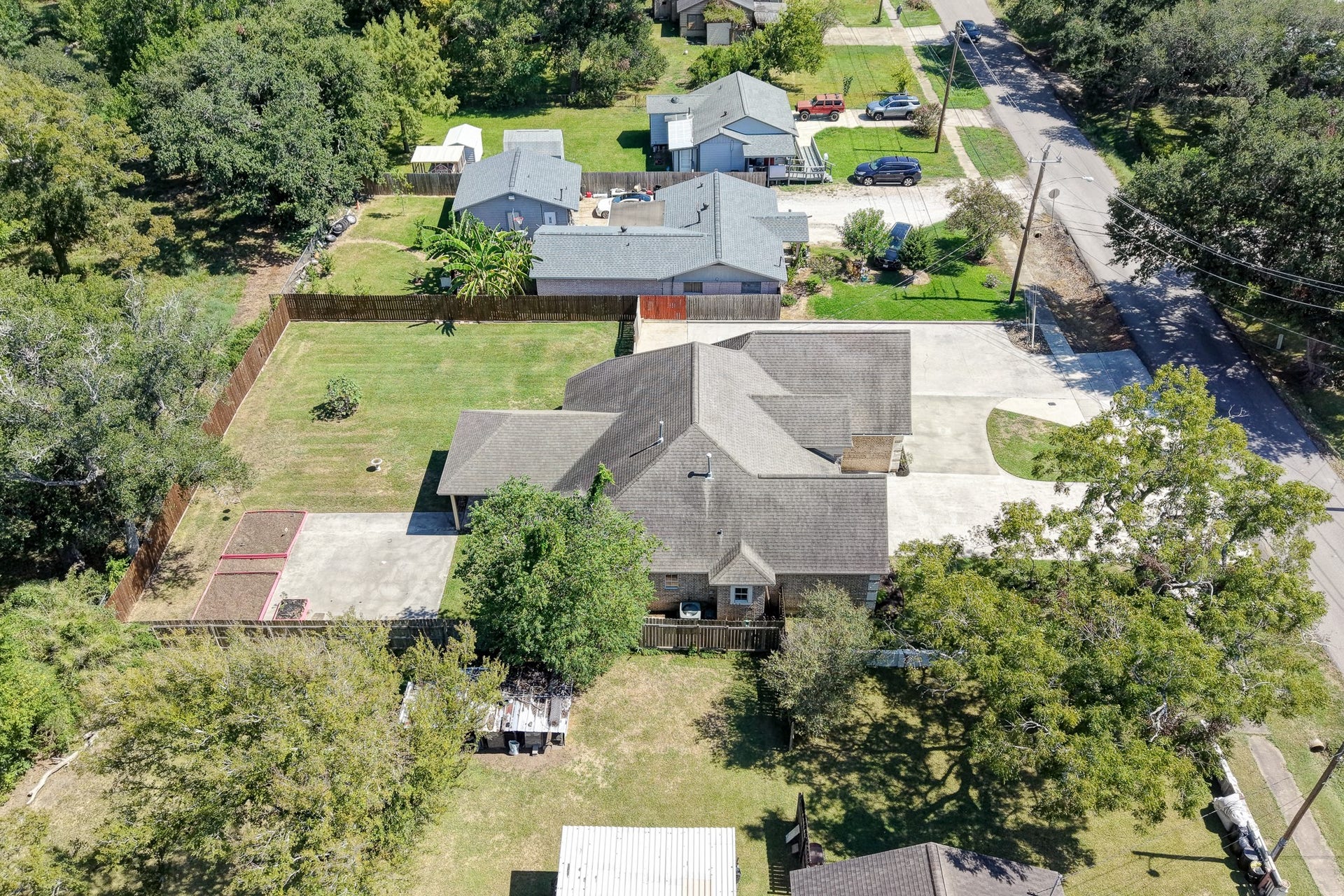 Aerial view showcasing the spacious lot, featuring two 100-square-foot garden beds and ample outdoor space.