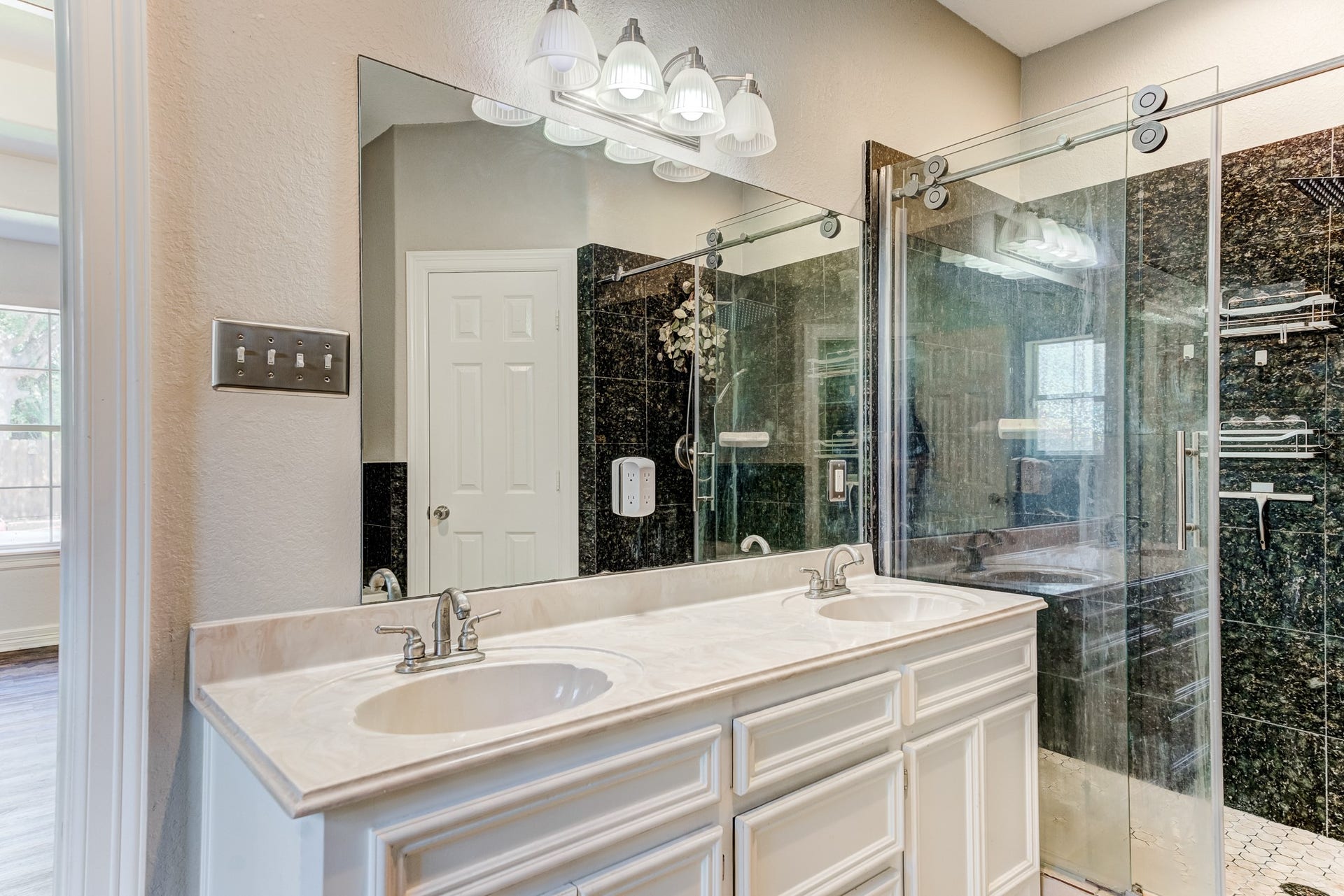 Elegant primary bathroom featuring dual vanities and custom finishes.