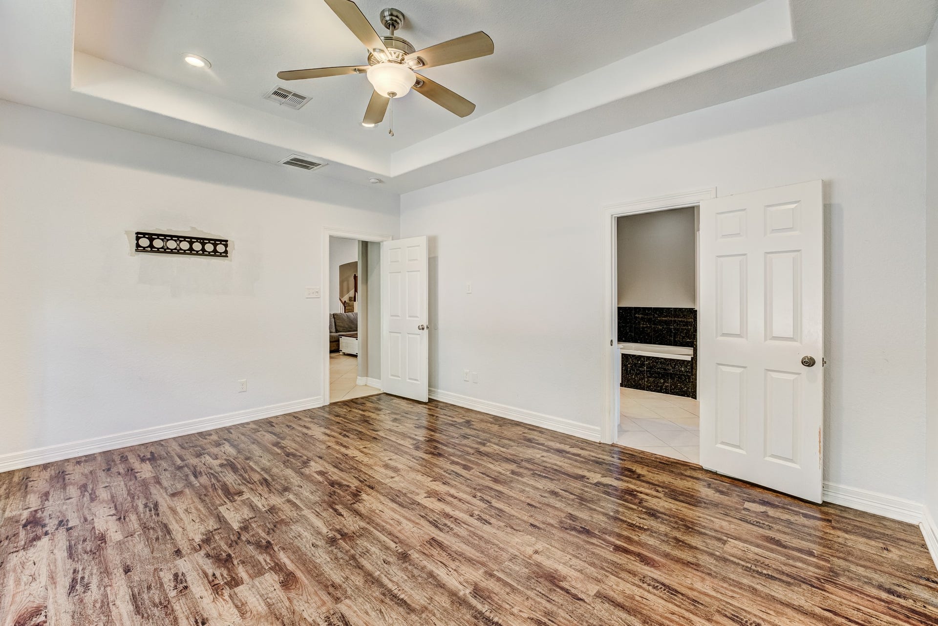 Spacious primary bedroom with elegant ceiling details and generous layout.