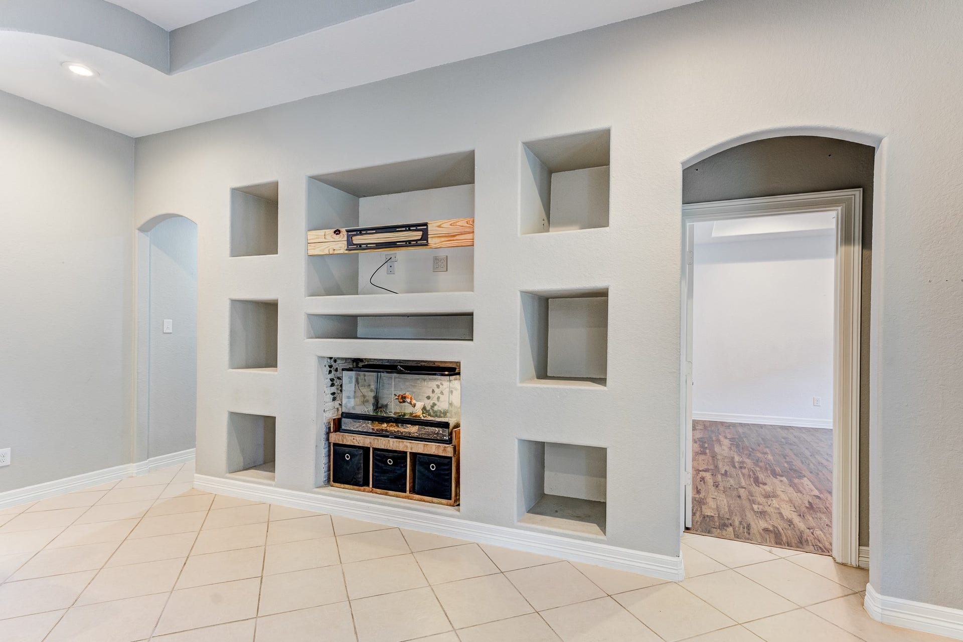 Custom built-in entertainment center and architectural niches add character to the living space.