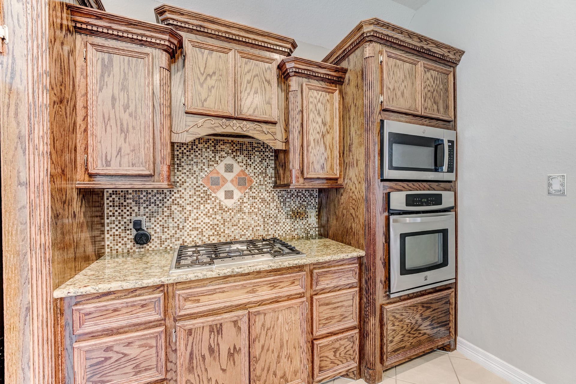 Well-appointed kitchen with decorative tile backsplash and built-in appliances.