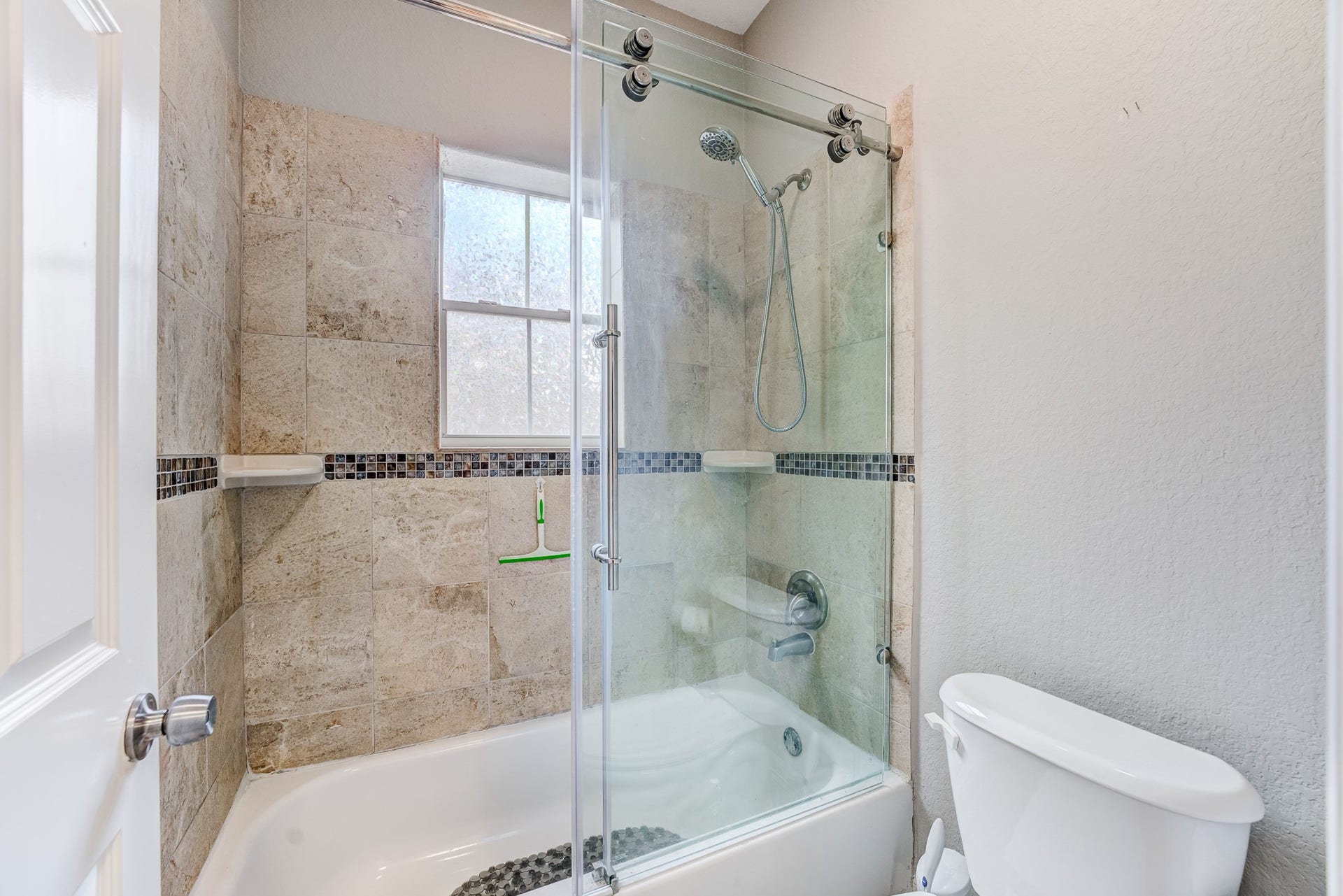 Full secondary bath with tiled shower/tub combination and modern fixtures.