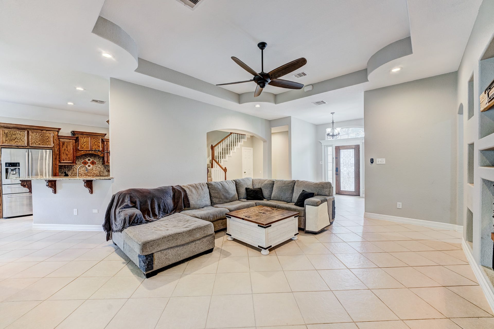 Open-concept family room with tray ceiling and seamless flow to the kitchen.