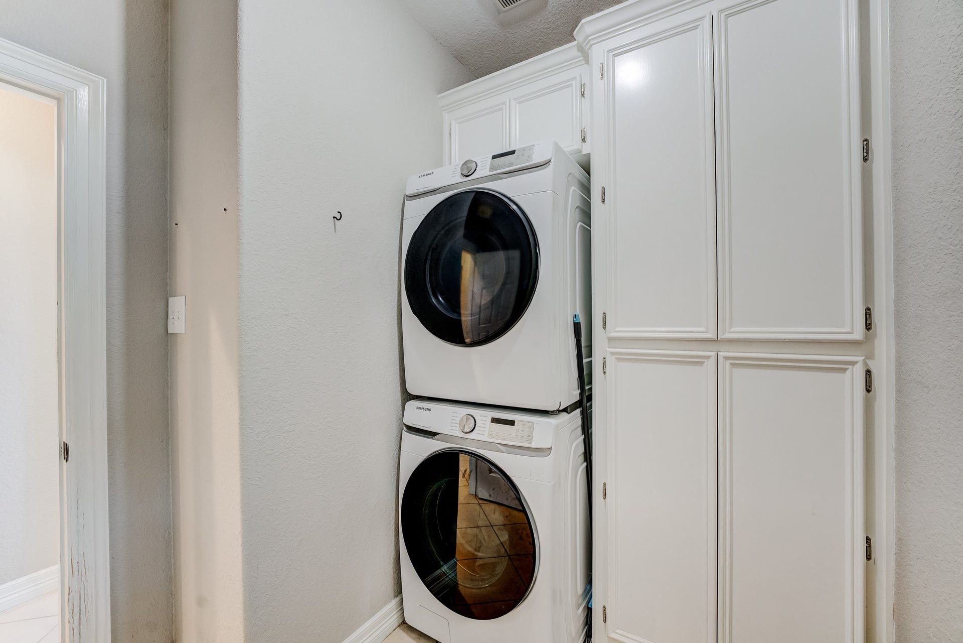 Dedicated laundry area with built-in cabinetry for additional storage and organization.