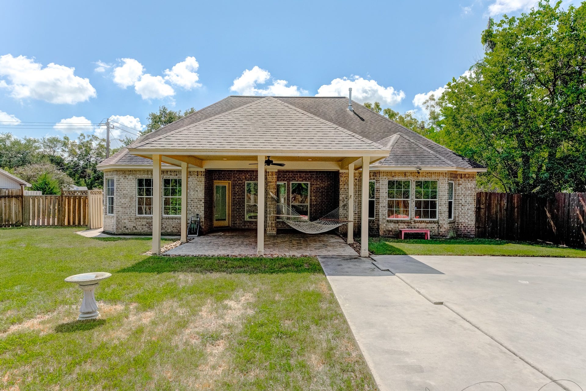 Covered outdoor living area overlooking the spacious fenced yard.