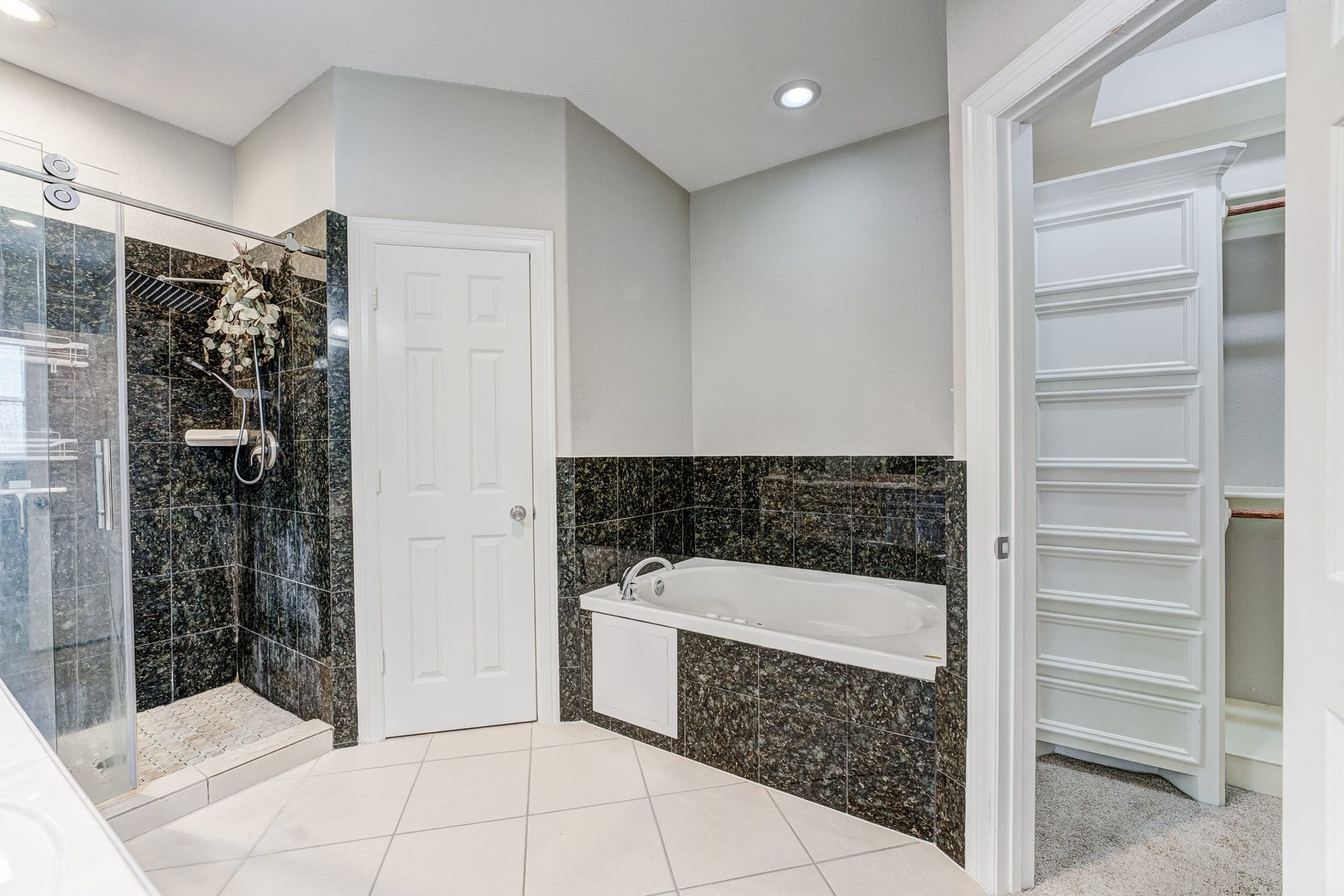 Spa-inspired primary bath with soaking tub, separate shower, and built-in storage.
