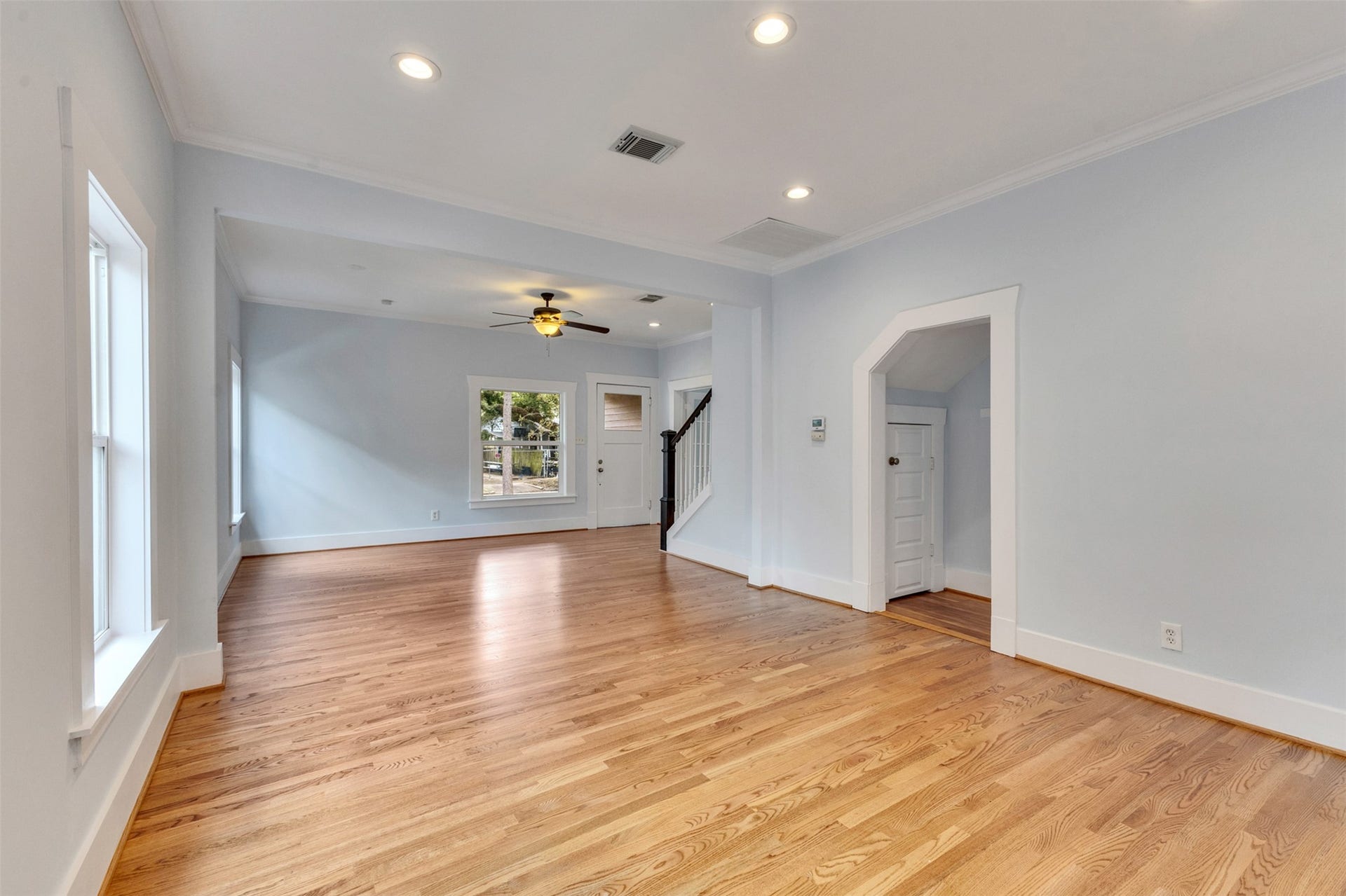 4534 Woodside Street, Houston, TX 77023 Spacious living area with beautiful hardwood floors, recessed lighting, and large windows offering plenty of natural light.