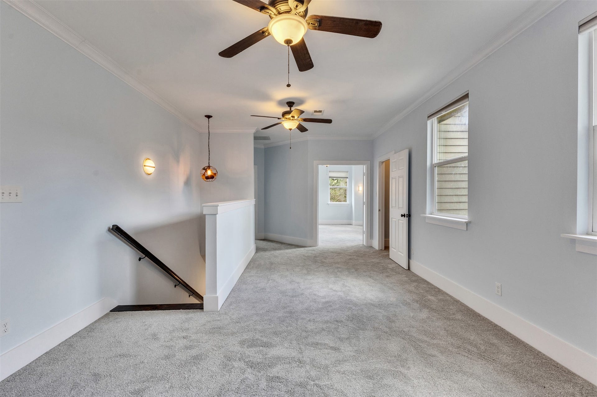 4534 Woodside Street, Houston, TX 77023 Spacious hallway with plush carpeting, ceiling fans, and ample natural light, leading to a bright room.