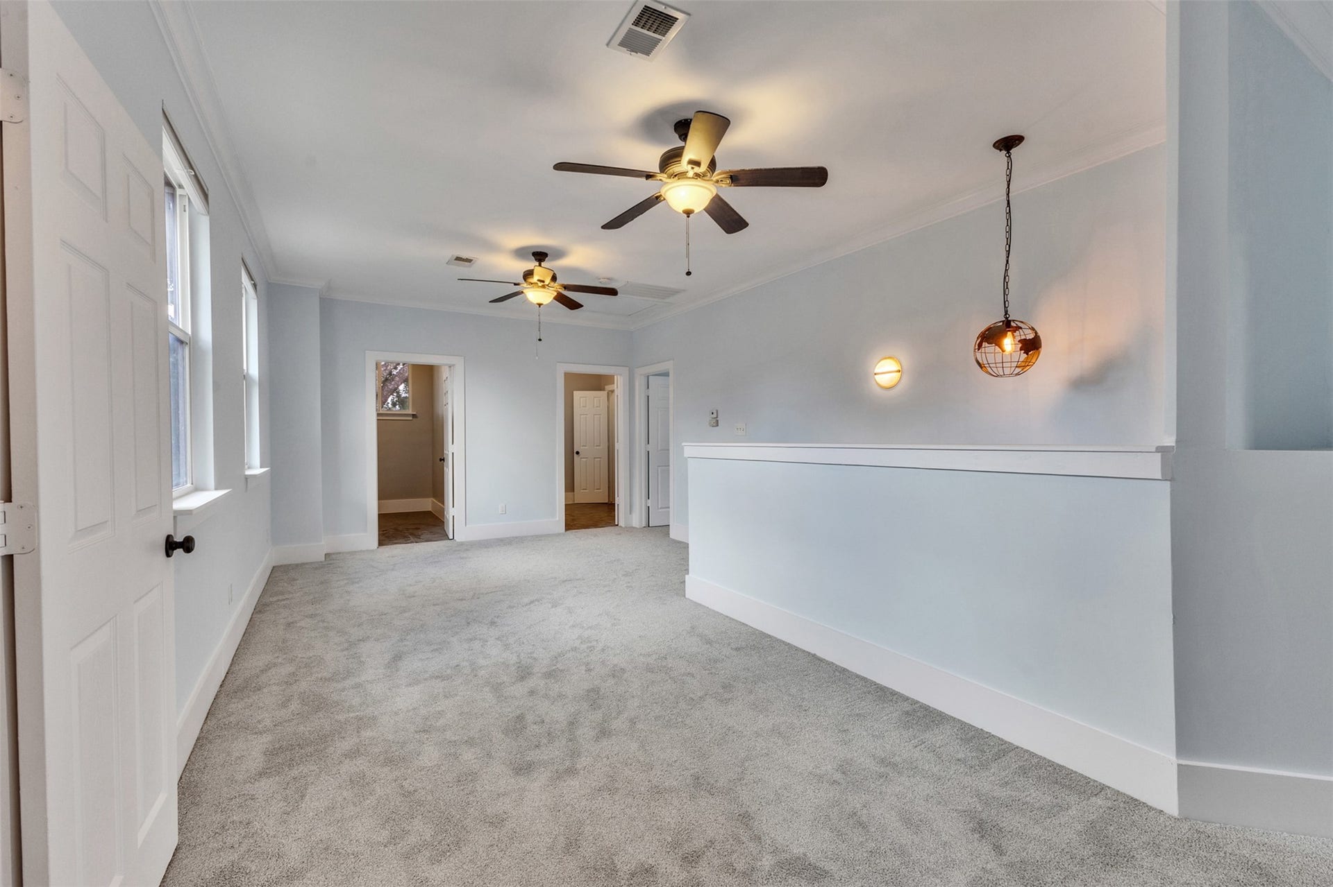 4534 Woodside Street, Houston, TX 77023 Spacious hallway with plush carpeting, modern ceiling fans, and stylish lighting, leading to multiple rooms for versatile use.