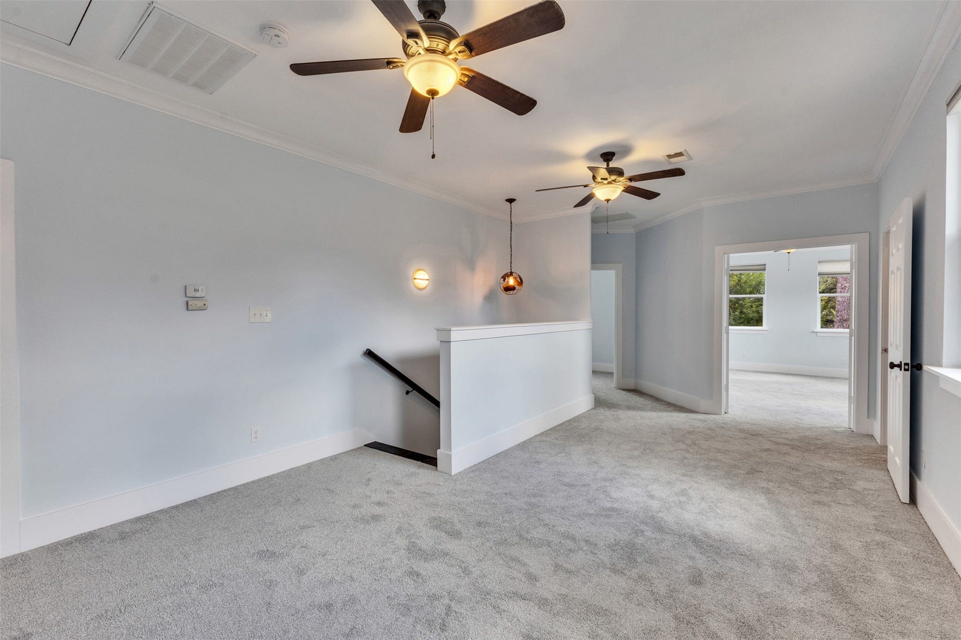 4534 Woodside Street, Houston, TX 77023 Spacious and airy landing area with plush carpeting, modern ceiling fans, and ample natural light, leading to additional rooms.