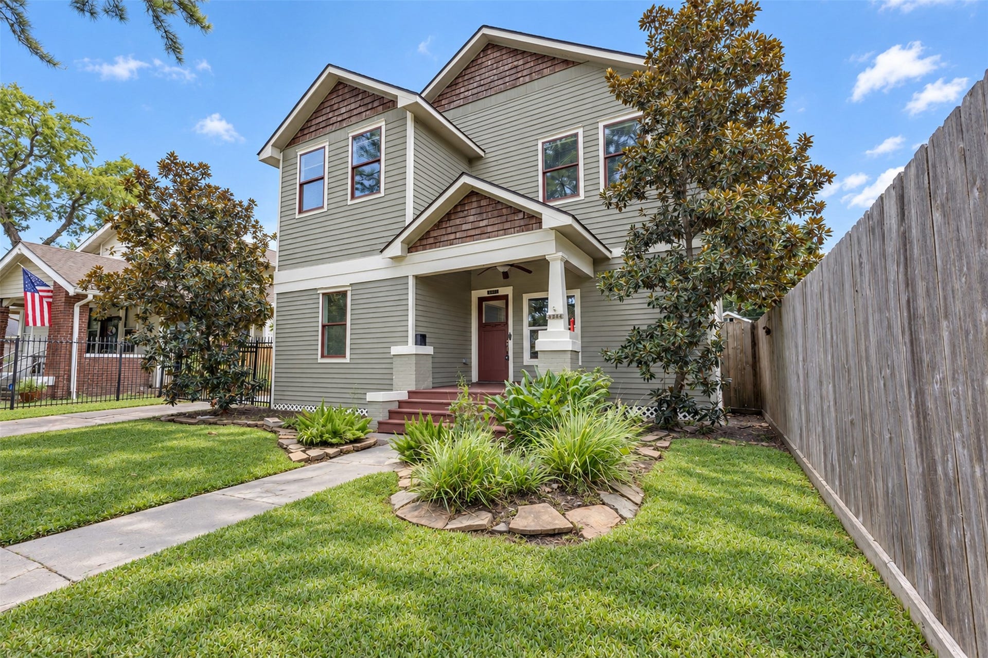 4534 Woodside Street, Houston, TX 77023 Charming two-story home with classic craftsman architecture, featuring a welcoming front porch, manicured lawn, and mature trees for added curb appeal.