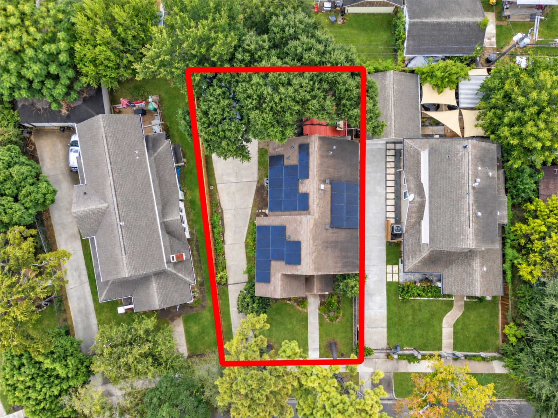 4534 Woodside Street, Houston, TX 77023 Charming home with solar panels, nestled between lush greenery, featuring a long driveway and ample backyard space.