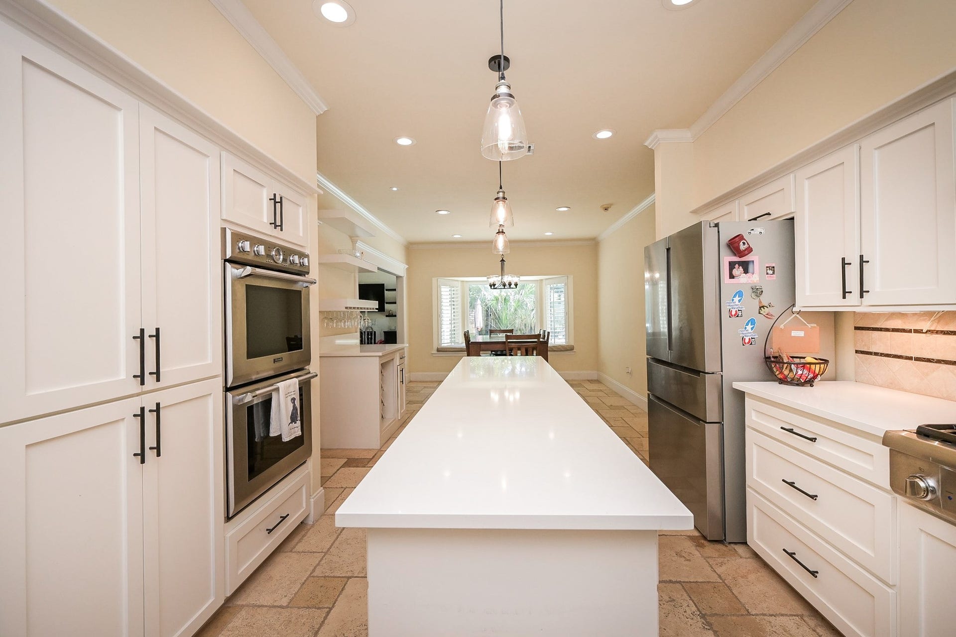 The open layout leads to a dining area with natural light from a large window.