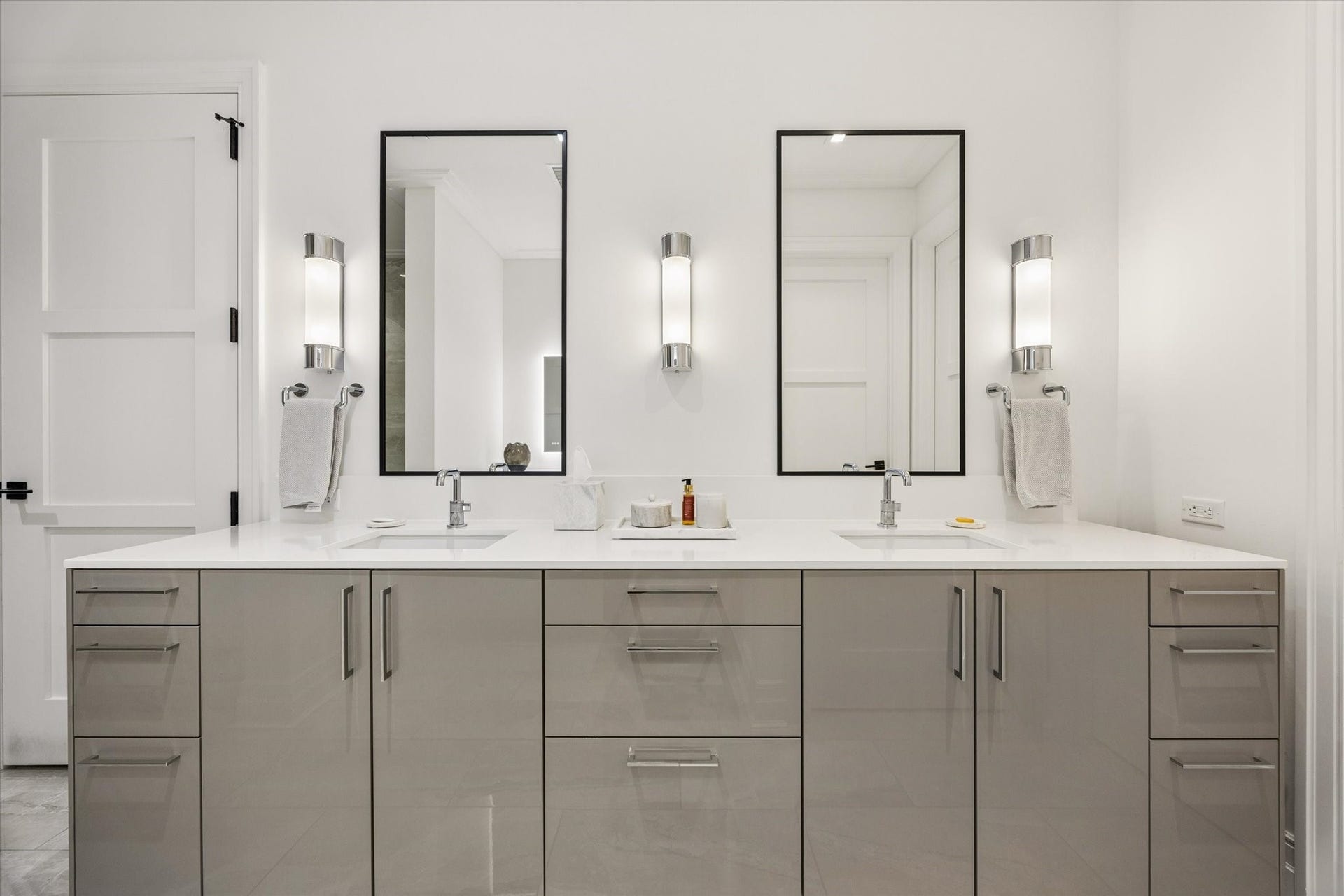 6017 Memorial Drive, #505, Houston, TX 77007 Elegance and symmetry define the primary bathroom's beautifully appointed dual-sink vanity. Sleek contemporary cabinetry, expansive quartz countertops, and polished chrome Brizo fixtures reflect the residence's European-inspired design. Individually framed mirrors and sophisticated wall sconces create a balanced architectural composition, while generous drawers and cabinet storage provide exceptional functionality without compromising the clean, refined aesthetic.