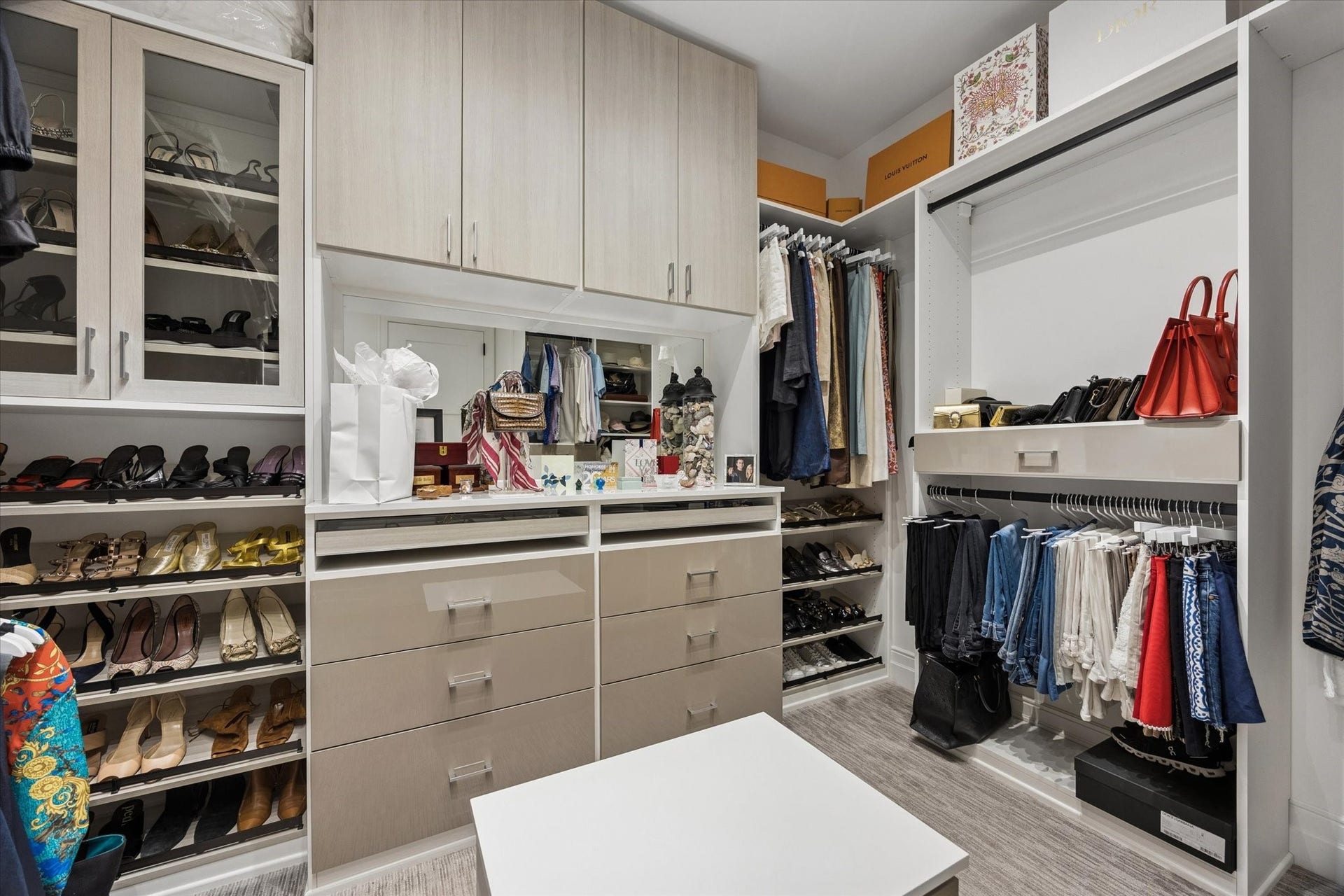6017 Memorial Drive, #505, Houston, TX 77007 An exceptional walk-in closet offers the organization and storage expected in a luxury residence. Thoughtfully designed custom cabinetry features extensive hanging space, built-in drawers, adjustable shelving, and dedicated displays for shoes and accessories. Glass-front cabinets add an elegant boutique-inspired touch, while the spacious layout and central island create a beautifully organized dressing environment that combines everyday convenience with refined sophistication.