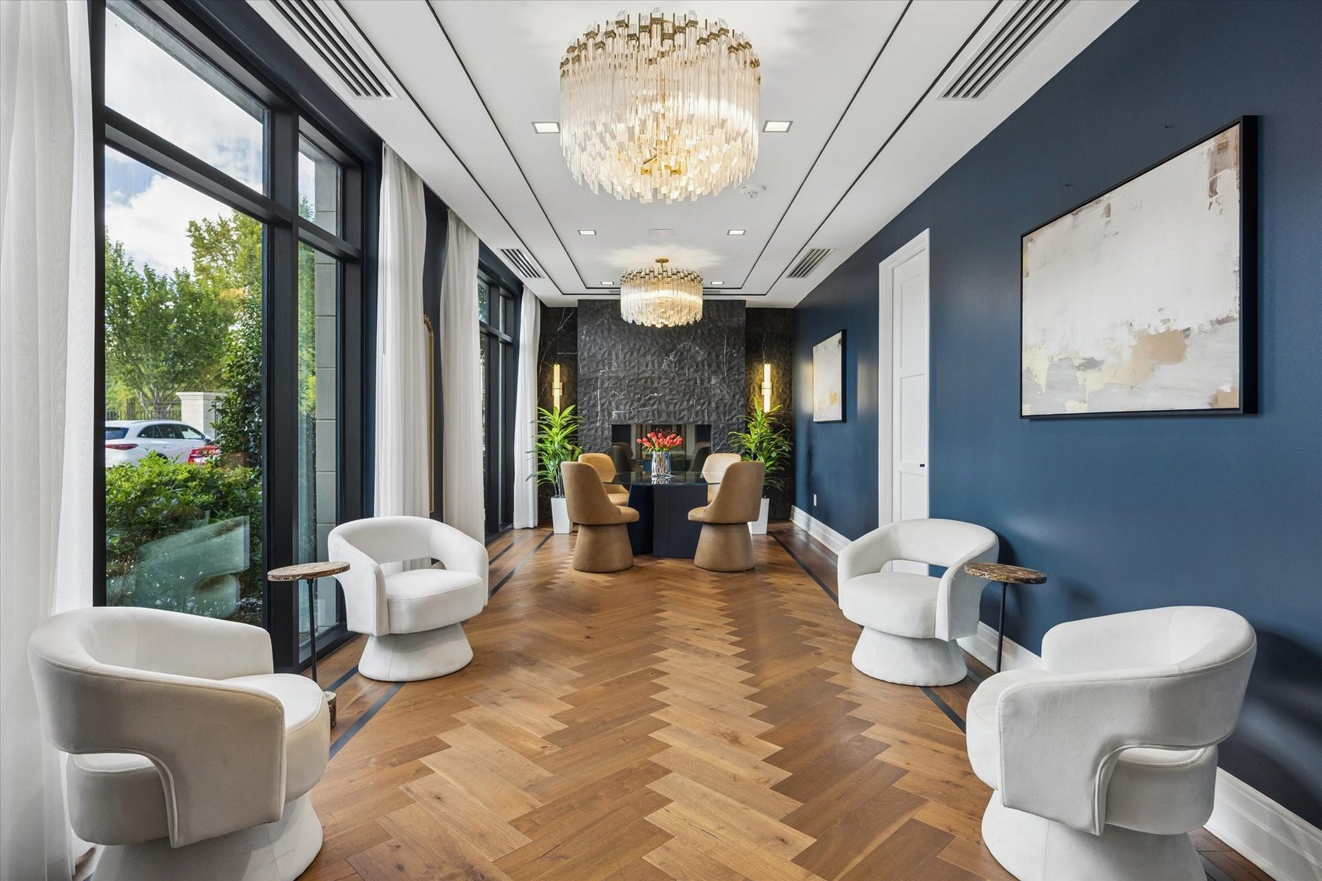 6017 Memorial Drive, #505, Houston, TX 77007 The Sophie's beautifully appointed resident lounge offers an atmosphere of refined elegance and understated luxury. Dramatic crystal chandeliers, rich herringbone wood flooring, sophisticated navy walls, and expansive windows create an inviting setting for relaxation and conversation. Thoughtfully arranged seating and exquisite architectural details reflect the building's commitment to exceptional design, providing residents with an elegant extension of their private homes.