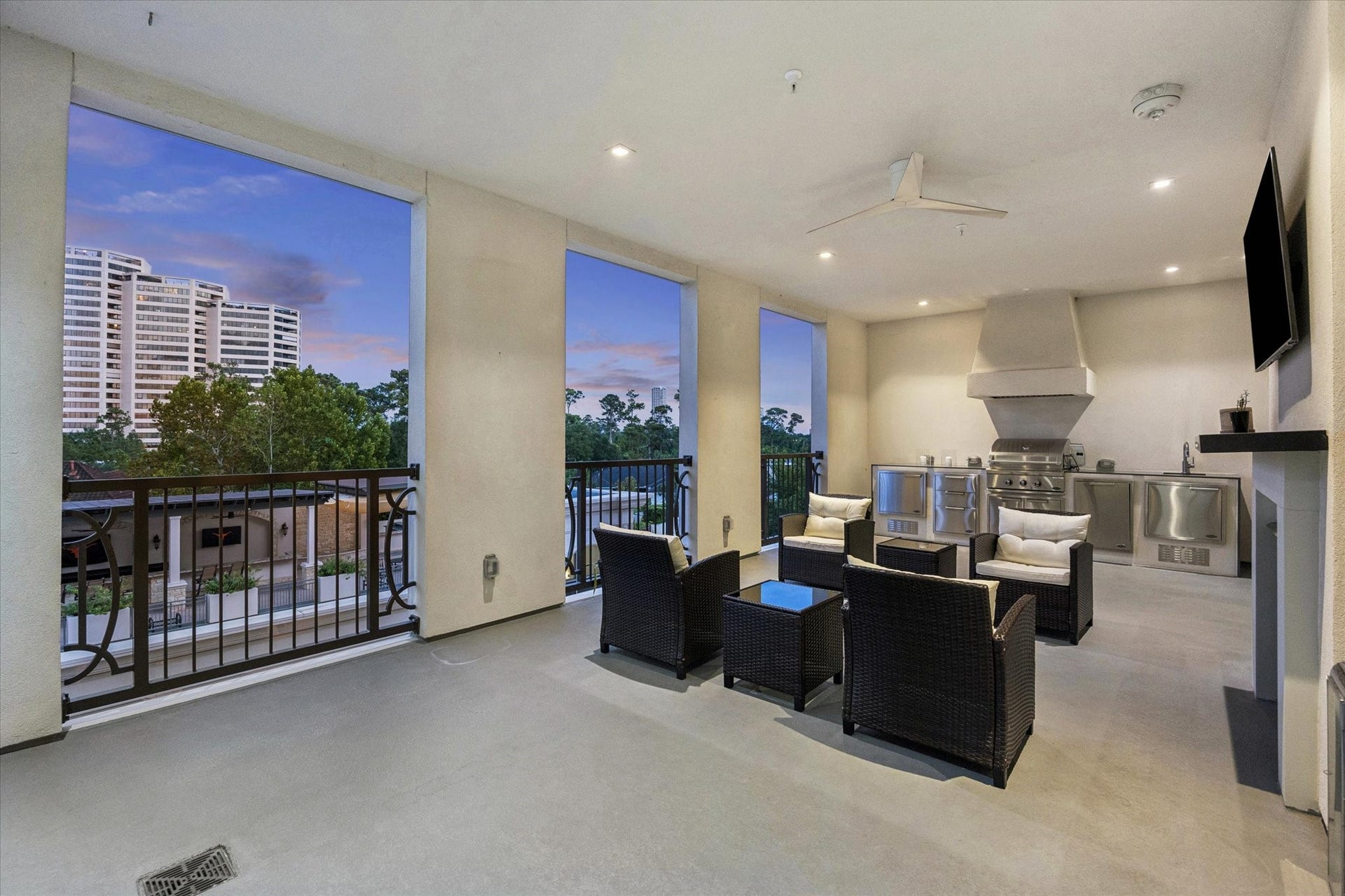 6017 Memorial Drive, #505, Houston, TX 77007 Enjoy elevated outdoor living from this expansive fifth-floor terrace, featuring sweeping views of the surrounding treetops and Houston skyline. Designed for year-round enjoyment, the covered terrace includes a fully equipped summer kitchen with a built-in gas grill, sink, and generous countertop space. A ceiling fan, recessed lighting, and comfortable seating areas create an exceptional setting for outdoor dining, entertaining, or simply relaxing above the city.