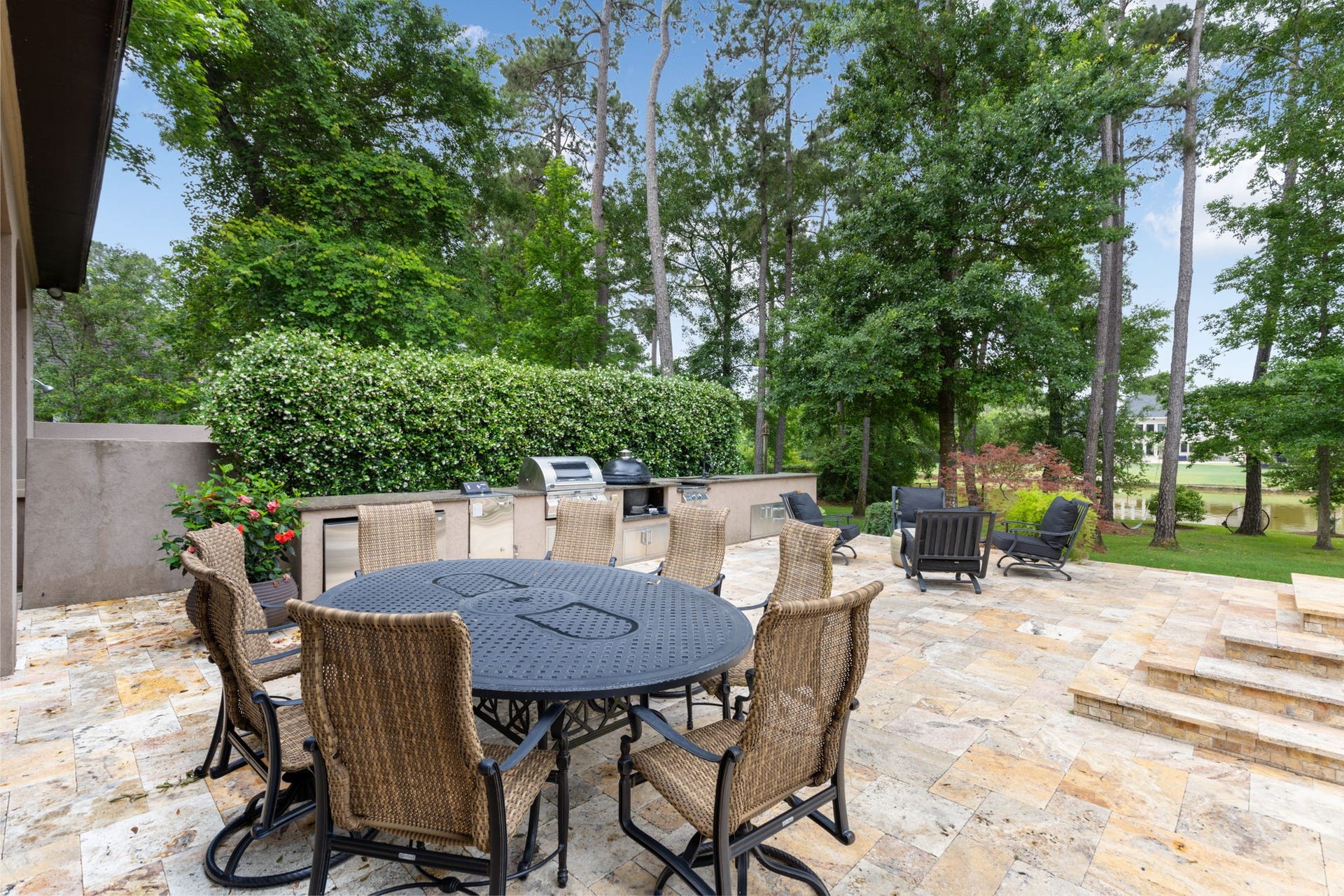 Exceptional Outdoor Kitchen built for the serious grillmasterfeaturing a large grill, smoker, Kamado Joe grill/smoker, ice maker, beverage refrigerator, burner, composite sink, and extensive granite prep space.