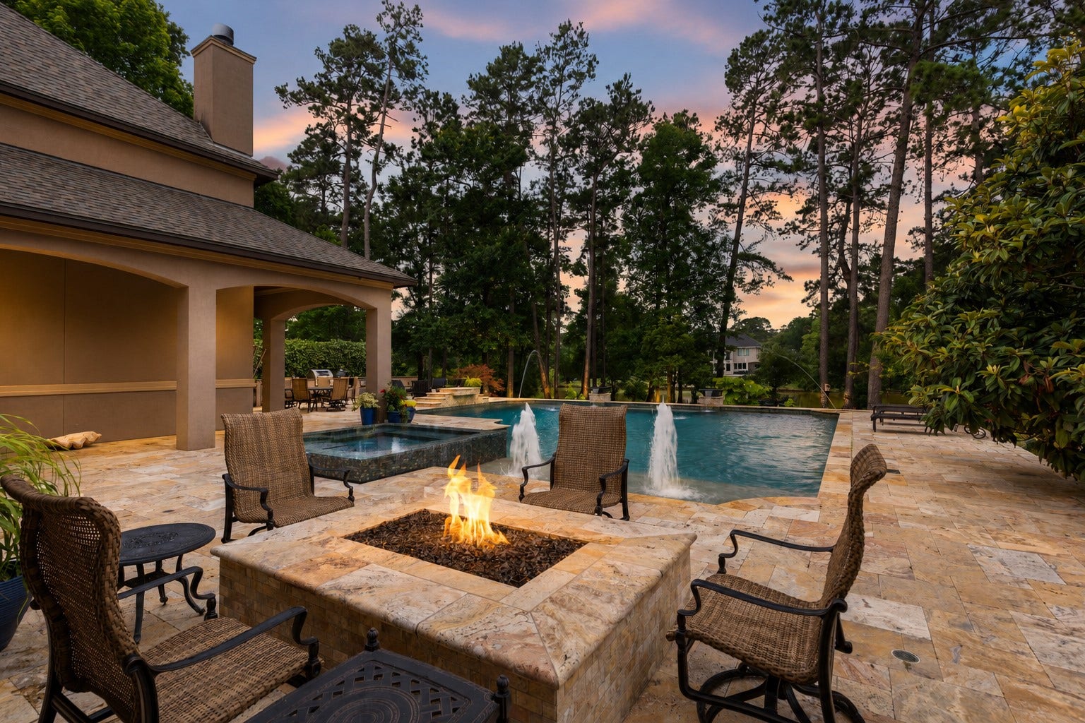 Resort-style backyard overlooking the community's largest lake, featuring over 2,000 SF of travertine decking, PebbleTec pool/spa, built-in fire pit, mature trees, and breathtaking waterfront views.