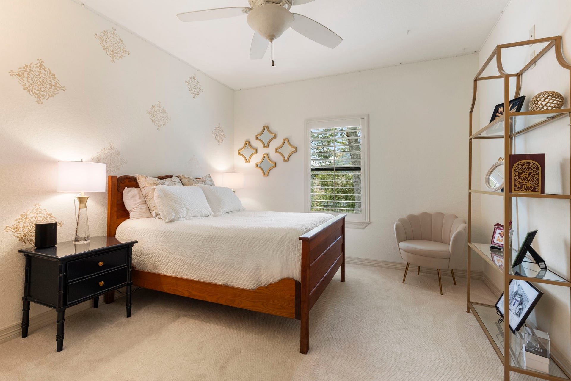 Privately positioned in its own upstairs wing with a step-up entry, updated carpet, ceiling fan, plantation-shuttered window, and an expansive walk-in closet with custom shelving.